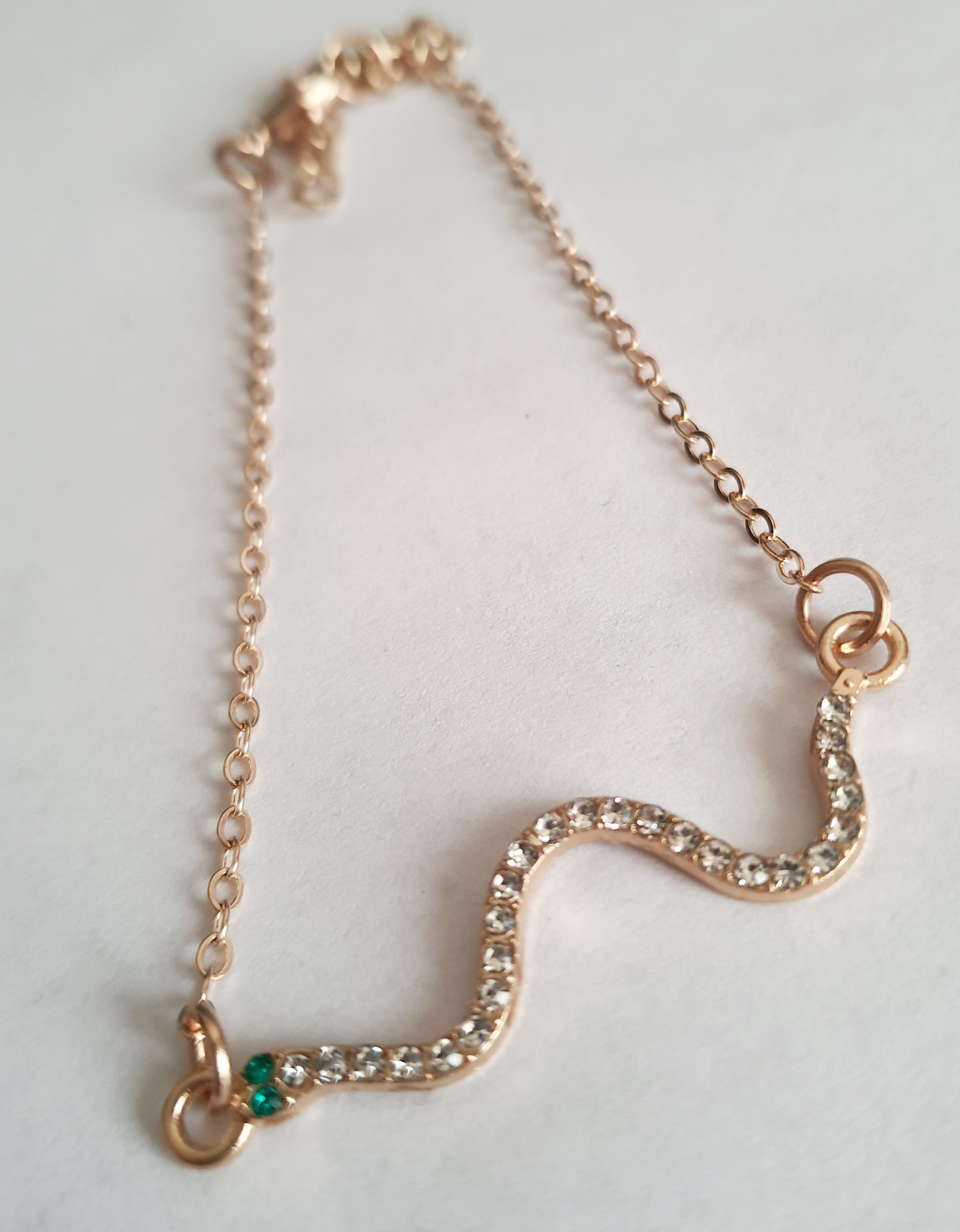 Bransoletka żmijka z cyrkoniami, złota, z zielonymi oczkami węża, długość 20–25 cm. Mistyczna, przyciągająca spojrzenia. Stal nierdzewna. Rouge Bizu.

