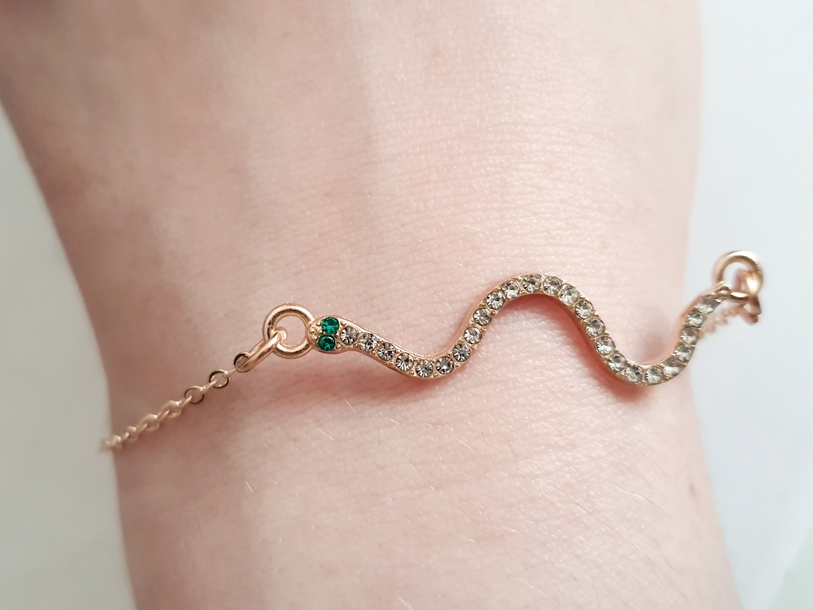 Bransoletka żmijka z cyrkoniami, złota, z zielonymi oczkami węża, długość 20–25 cm. Mistyczna, przyciągająca spojrzenia. Stal nierdzewna. Rouge Bizu.

