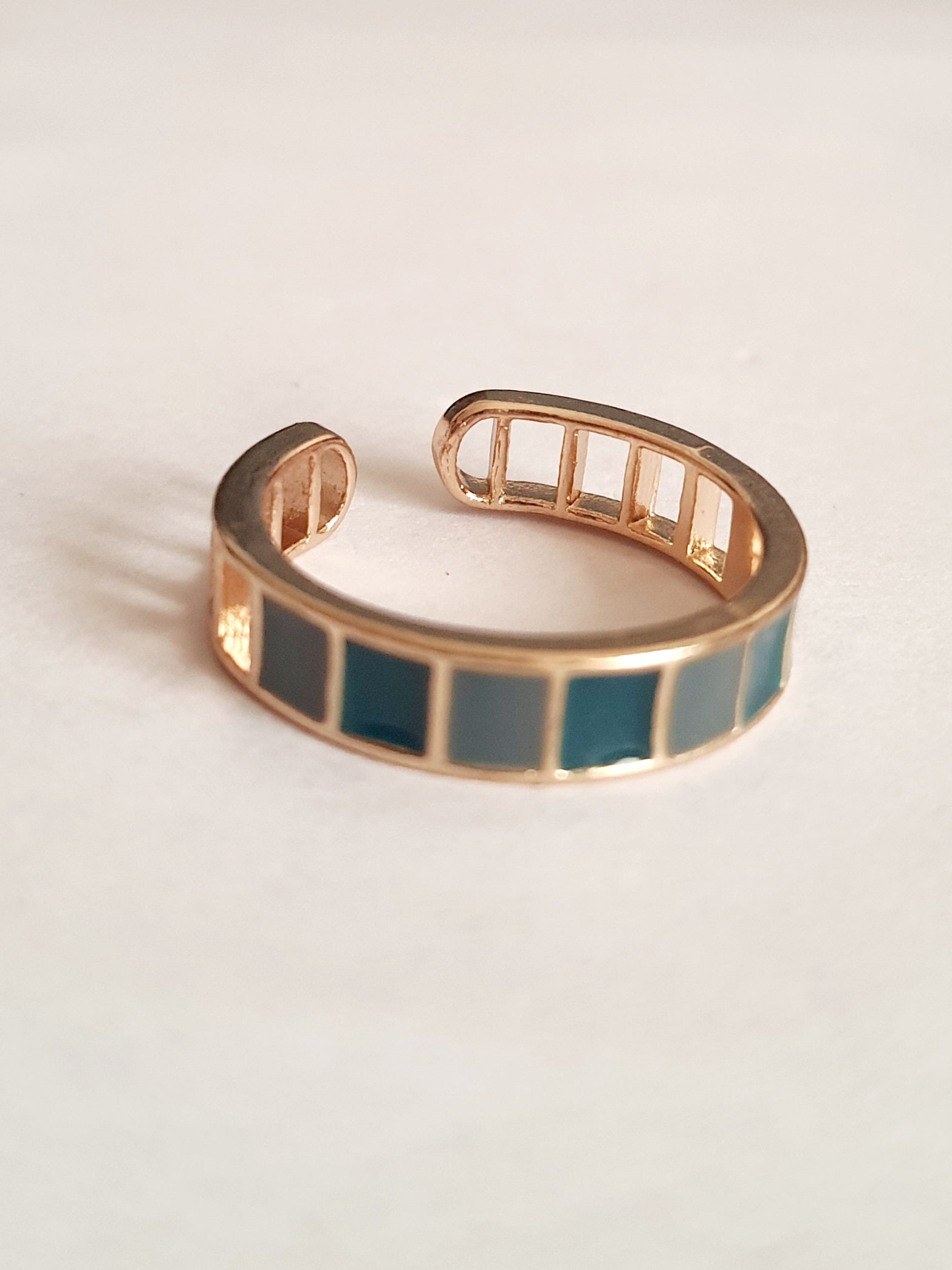 Pierścionek ze stali nierdzewnej z niebieskimi prostokątnymi emaliowanymi segmentami. Styl nowoczesny, minimalistyczny, art deco. Rozmiar 16 mm, otwarty. Geometryczny wzór w odcieniach błękitu. RougeBizu.

