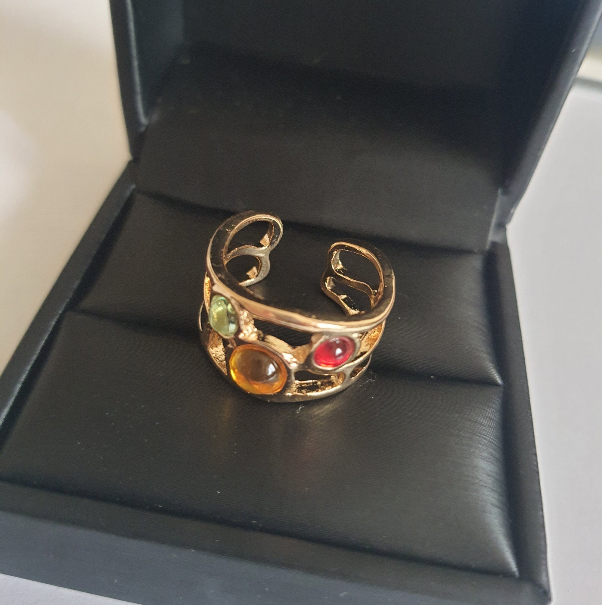 Artystyczny pierścionek ze złotej stali nierdzewnej z kolorowymi szklanymi oczkami – czerwonym, żółtym i niebieskim. Rozmiar 17 mm. Styl boho i handmade. RougeBizu.

