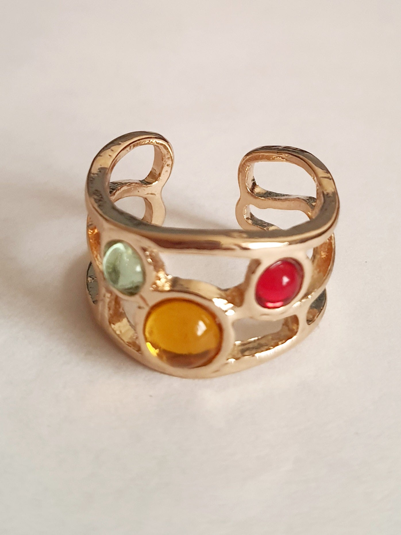 Artystyczny pierścionek ze złotej stali nierdzewnej z kolorowymi szklanymi oczkami – czerwonym, żółtym i niebieskim. Rozmiar 17 mm. Styl boho i handmade. RougeBizu.


