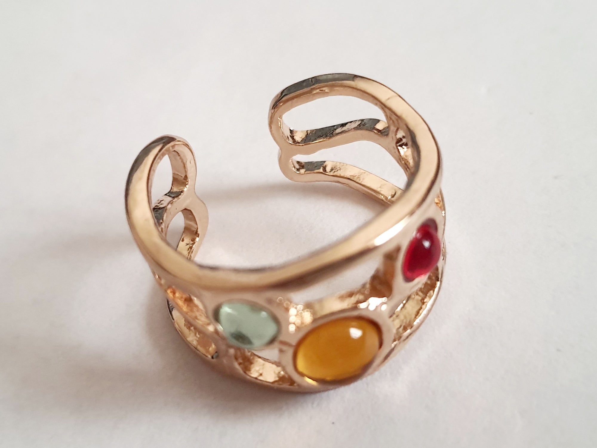 Artystyczny pierścionek ze złotej stali nierdzewnej z kolorowymi szklanymi oczkami – czerwonym, żółtym i niebieskim. Rozmiar 17 mm. Styl boho i handmade. RougeBizu.

