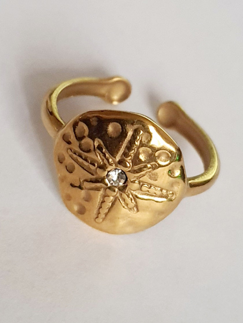 Złoty pierścionek regulowany, rozmiar 19 mm, z motywem tłoczonej gwiazdy morskiej i centralną cyrkonią. Styl boho i vintage, stal nierdzewna, stal chirurgiczna. Rouge Bizu.

