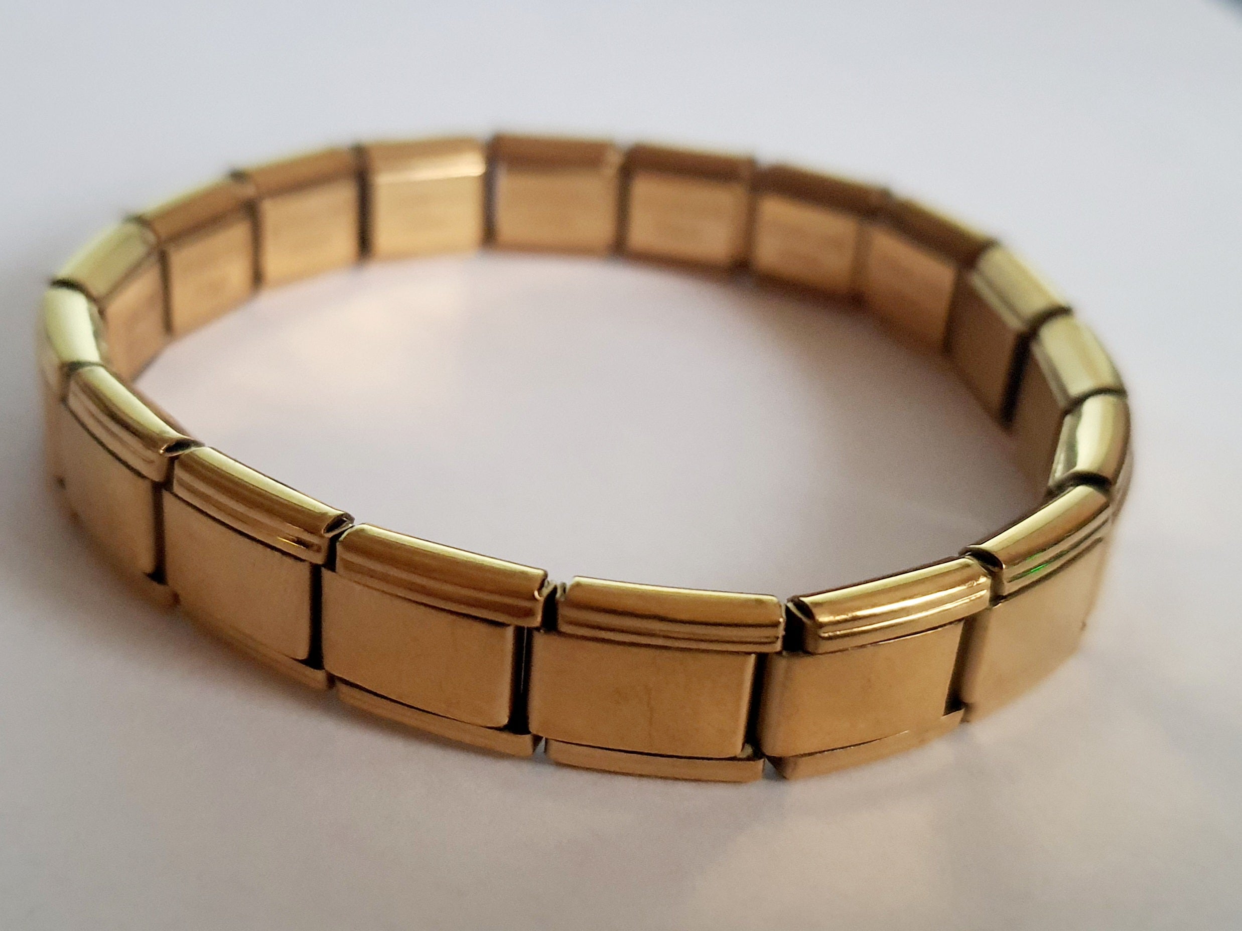 Złota, elastyczna bransoletka z szerokimi ogniwami w stylu retro, minimalistyczna, elegancka, długość 20 cm. Wykonana ze stali nierdzewnej, stal chirurgiczna. Rouge Bizu.

