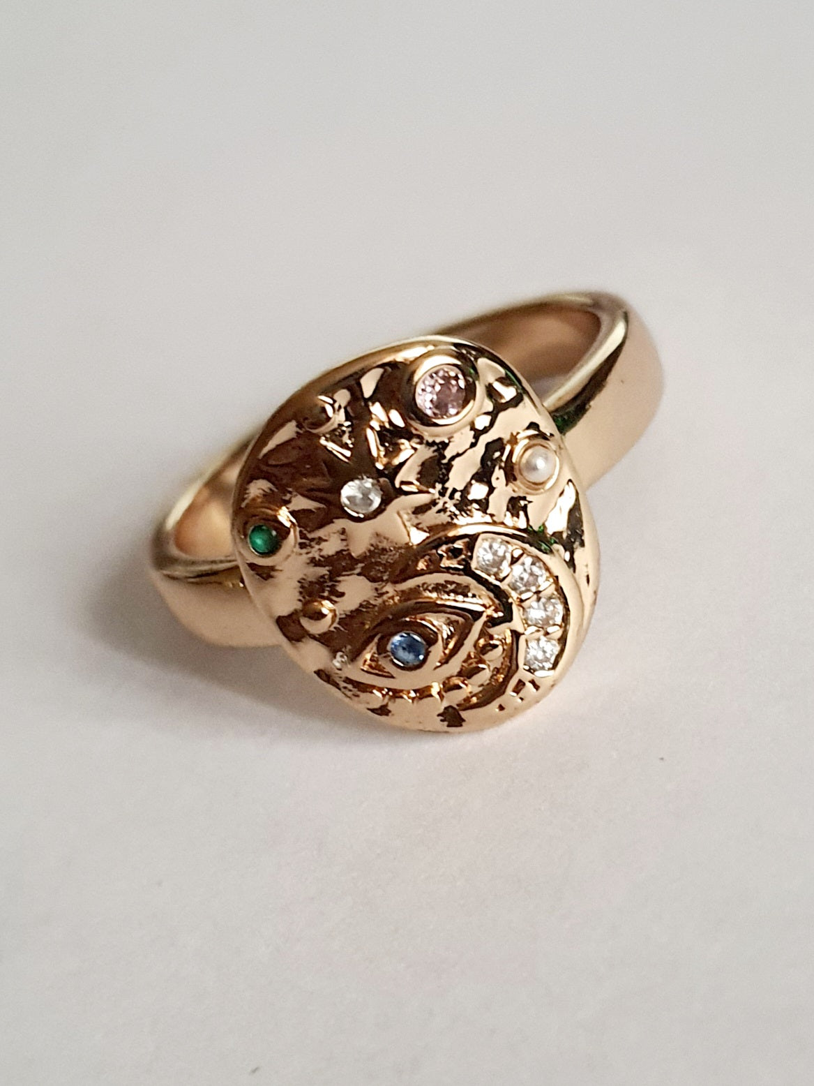 Złoty pierścionek 19 mm ze zdobieniami w kształcie księżyca, oka, gwiazd i kolorowych kamieni. Styl mistyczny, astrologiczny. Stal nierdzewna. Rouge Bizu.

