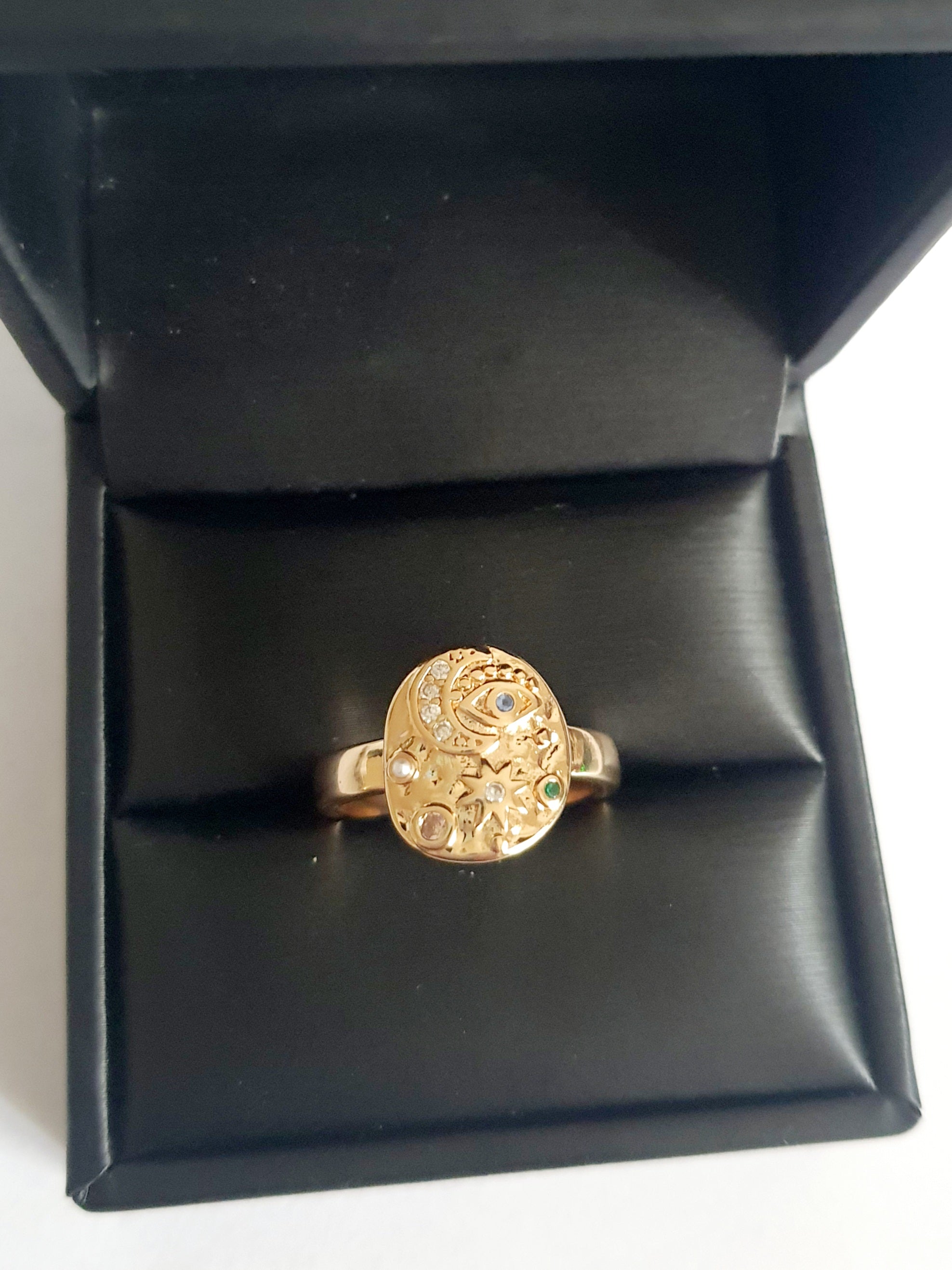 Złoty pierścionek 19 mm ze zdobieniami w kształcie księżyca, oka, gwiazd i kolorowych kamieni. Styl mistyczny, astrologiczny. Stal nierdzewna. Rouge Bizu.


