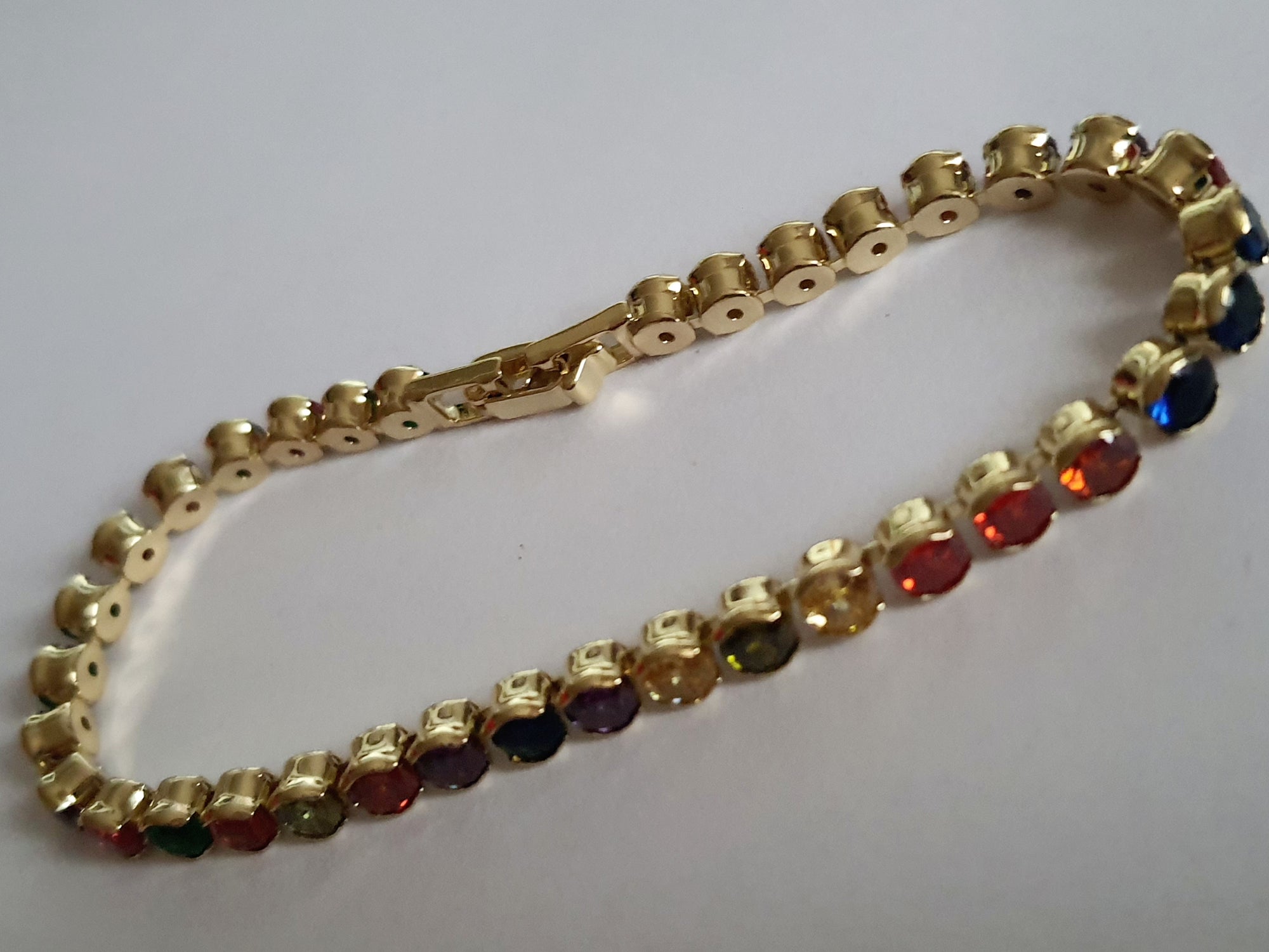 Bransoletka tenisowa stal nierdzewna, złota z kolorowymi cyrkoniami, długość 19 cm, Rouge Bizu.

