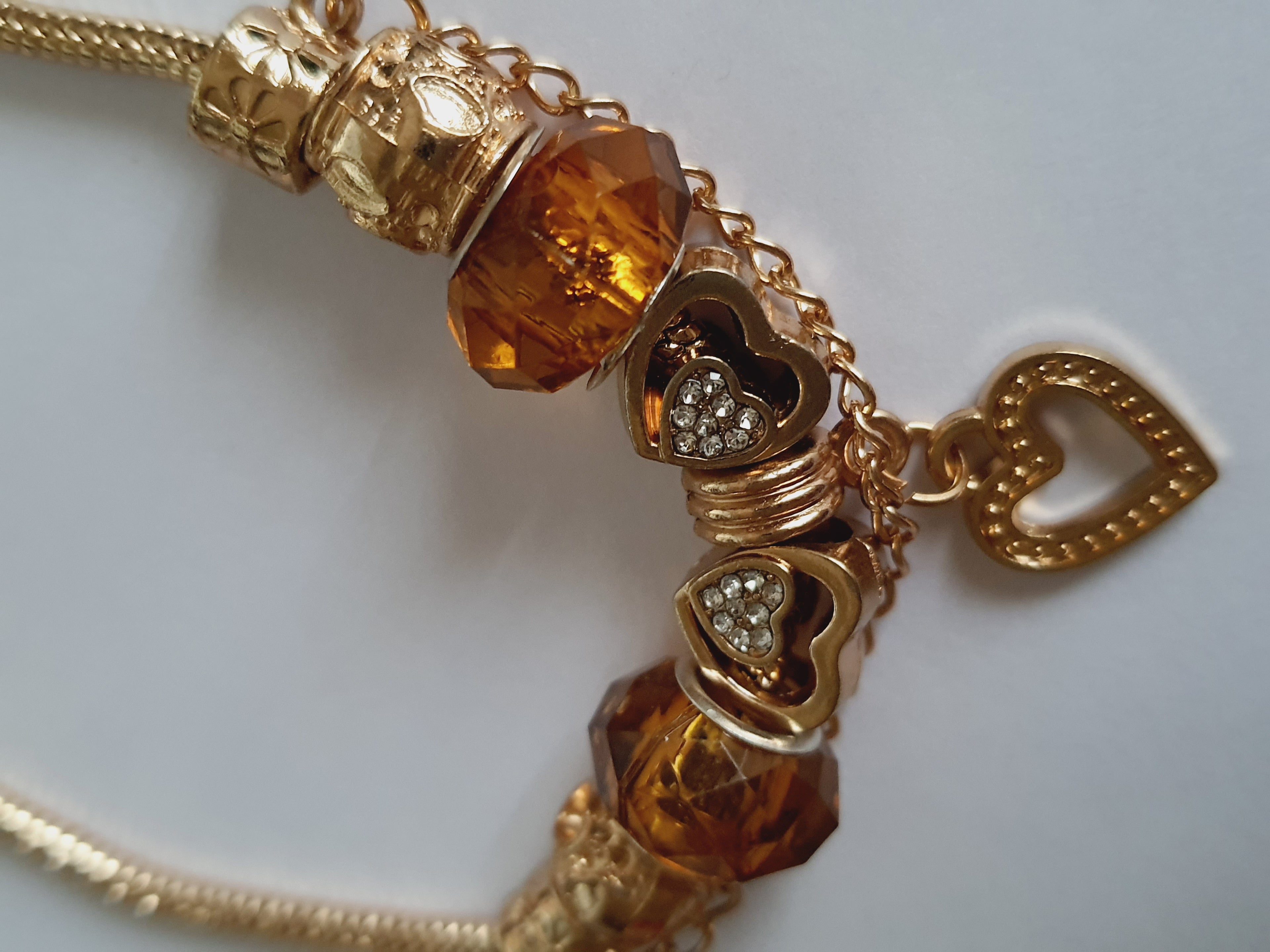 Przepiękna bransoletka stal nierdzewna z charmsami w pięknym, ciepłym bursztynowym kolorze. kolor wyrobu ciepłe złoto. charmsy z blokadą, wyjątkowo śliczny i elegancki wyrób. stal nierdzewna. rougebizu