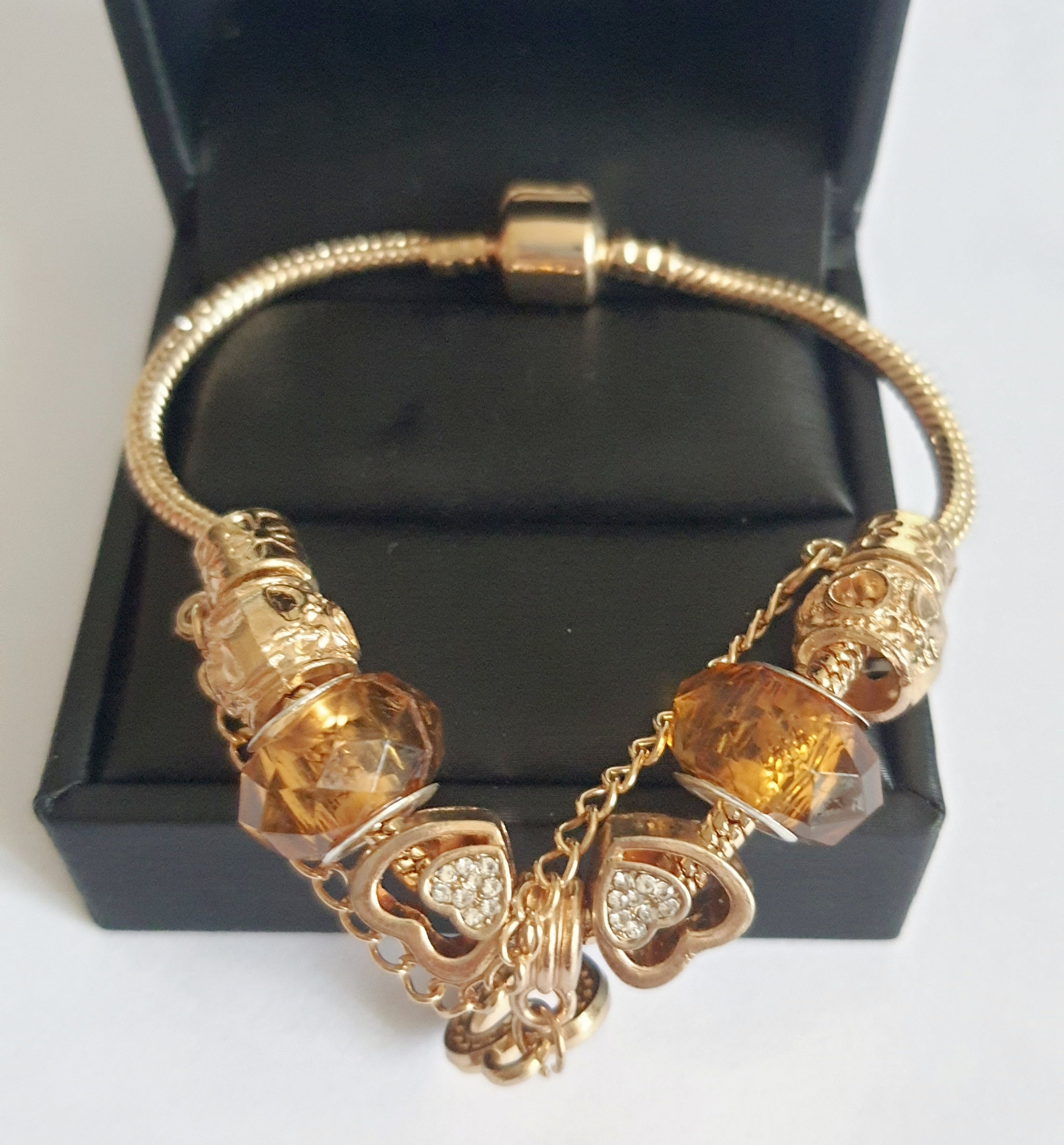 Przepiękna bransoletka stal nierdzewna z charmsami w pięknym, ciepłym bursztynowym kolorze. kolor wyrobu ciepłe złoto. charmsy z blokadą, wyjątkowo śliczny i elegancki wyrób. stal nierdzewna. rougebizu