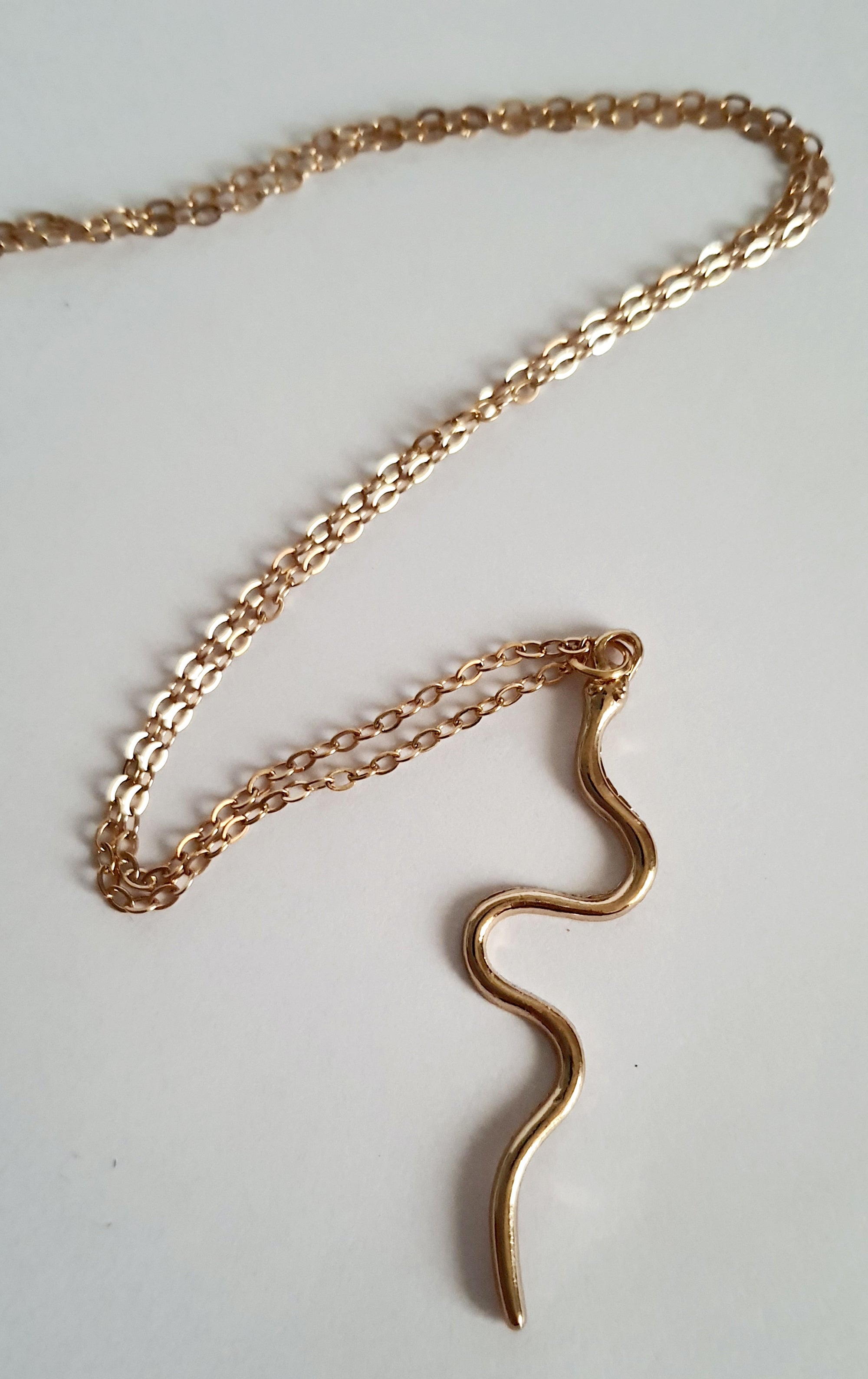 Złoty łańcuszek z falistą zawieszką, w kształcie węża, stal nierdzewna, długość regulowana 46–53 cm. Rouge Bizu.