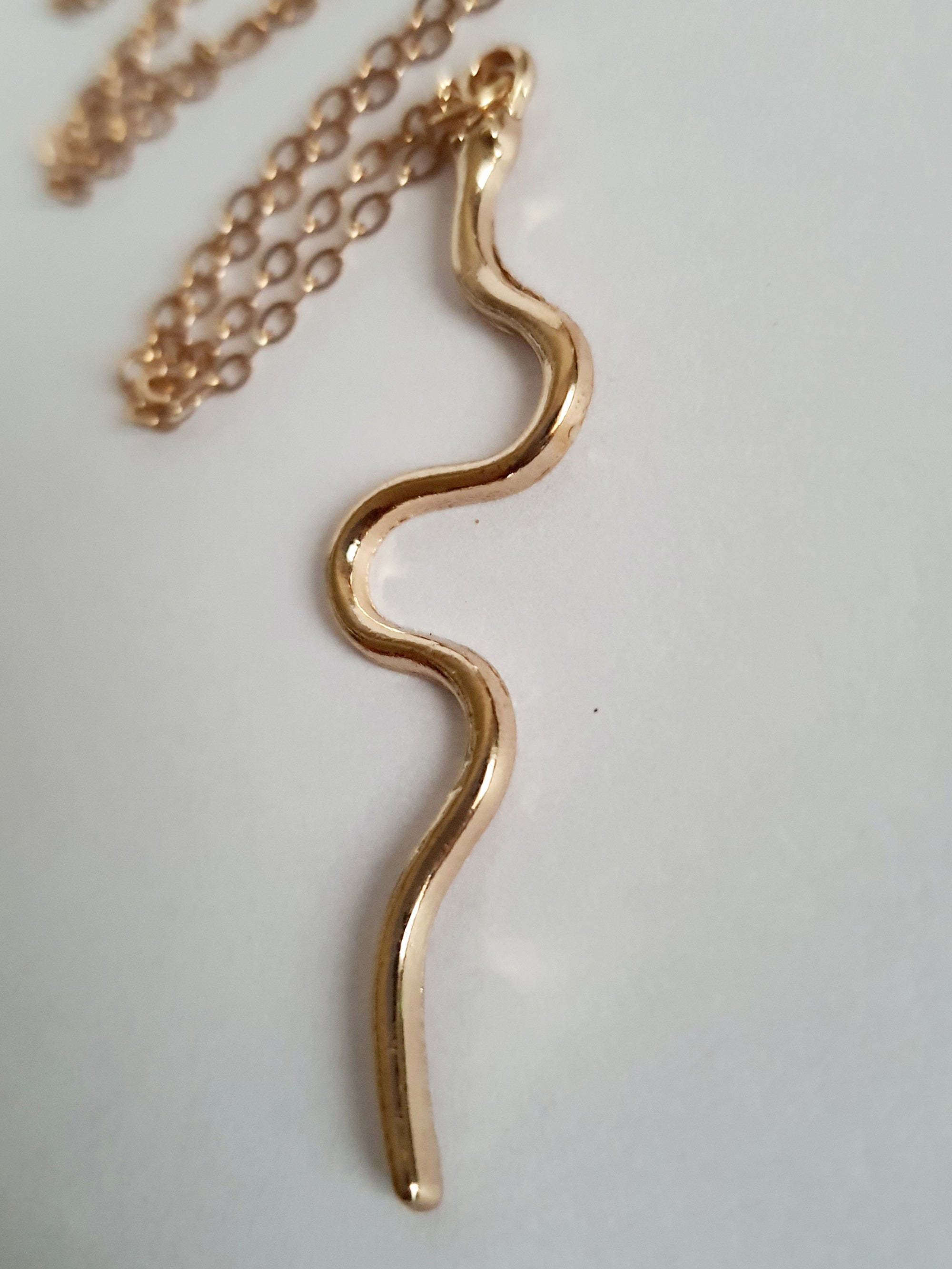 Złoty łańcuszek z falistą zawieszką, w kształcie węża, stal nierdzewna, długość regulowana 46–53 cm. Rouge Bizu.