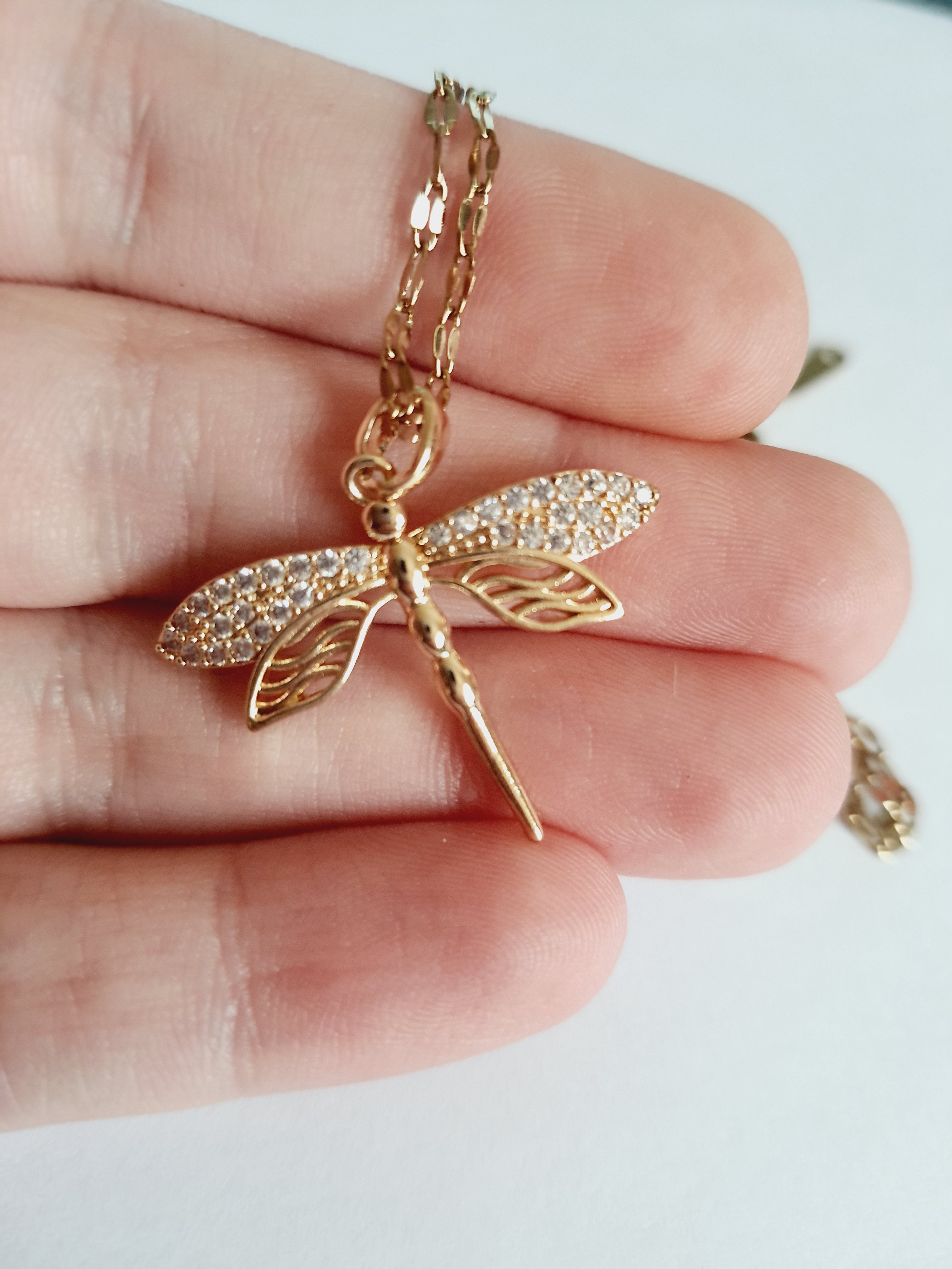 Złoty łańcuszek z zawieszką w kształcie ważki ozdobionej cyrkoniami, długość 41-47 cm.

