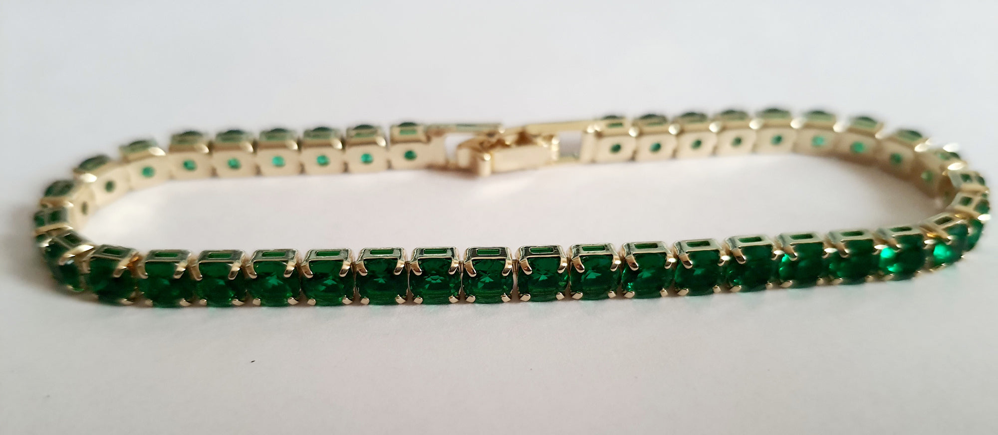 Bransoletka tenisowa złota ze stali nierdzewnej z szmaragdowymi kryształami, długość 18 cm, elegancka i klasyczna, RougeBizu.

