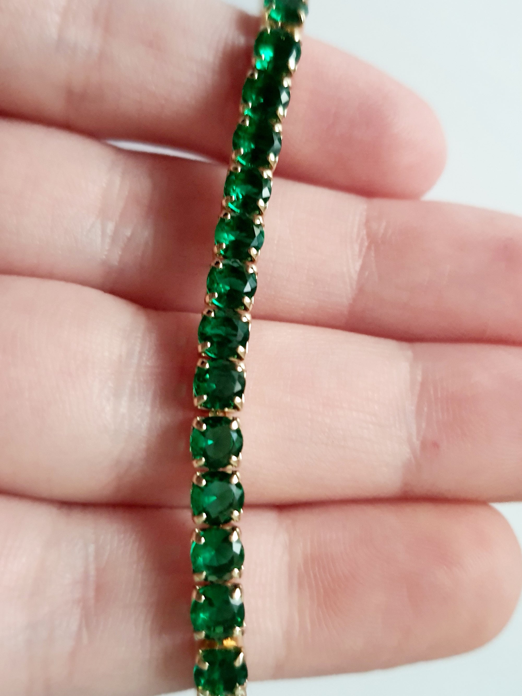 Bransoletka tenisowa złota ze stali nierdzewnej z szmaragdowymi kryształami, długość 18 cm, elegancka i klasyczna, RougeBizu.

