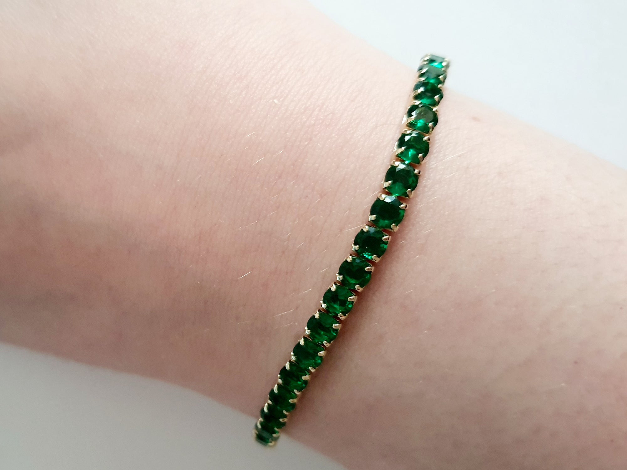 Bransoletka tenisowa złota ze stali nierdzewnej z szmaragdowymi kryształami, długość 18 cm, elegancka i klasyczna, RougeBizu.

