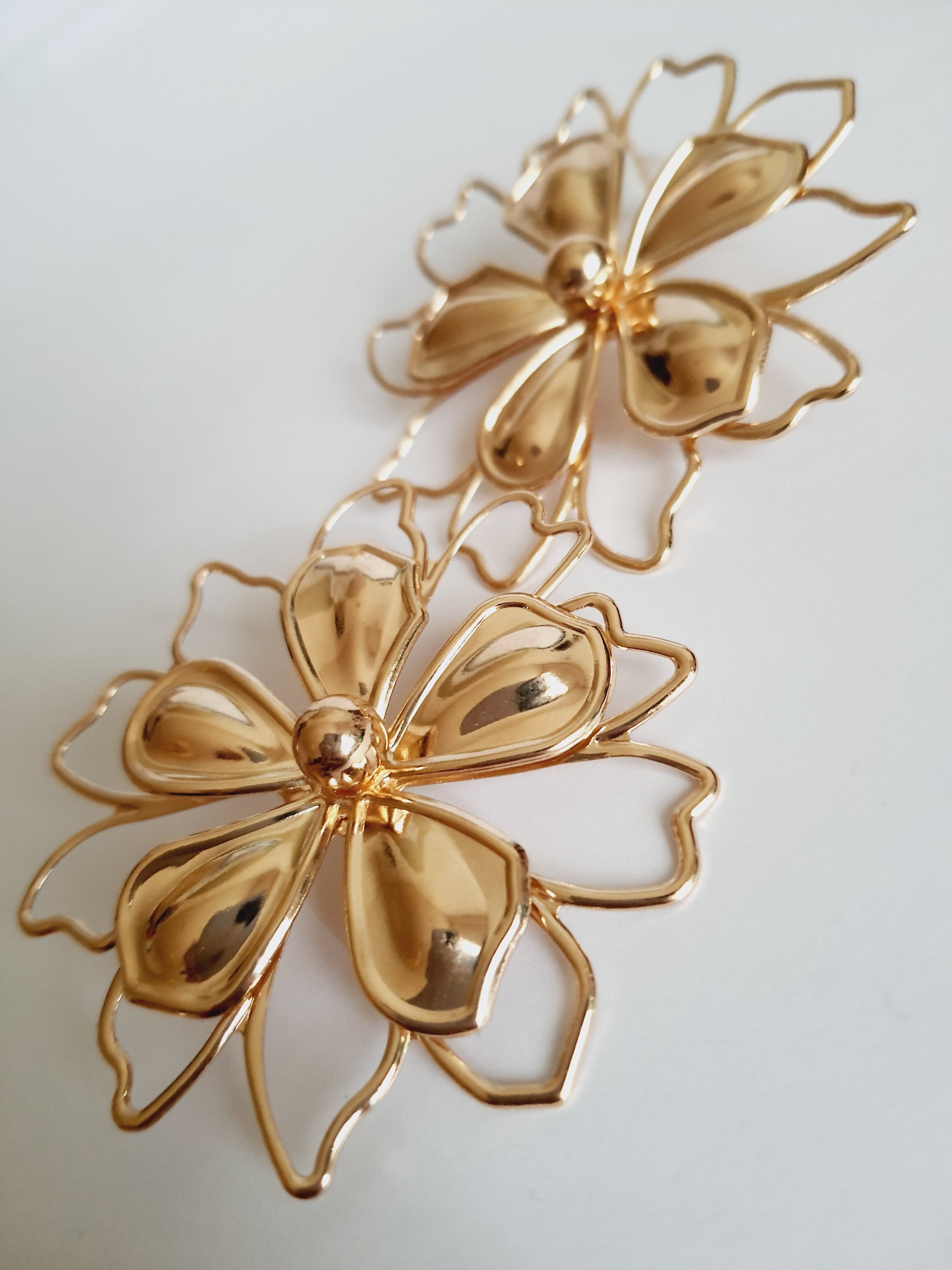 Złote kolczyki w kształcie dużych ażurowych kwiatów, wykonane ze stali nierdzewnej, średnica 6 cm, styl artystyczny, glamour i boho. Rouge Bizu.