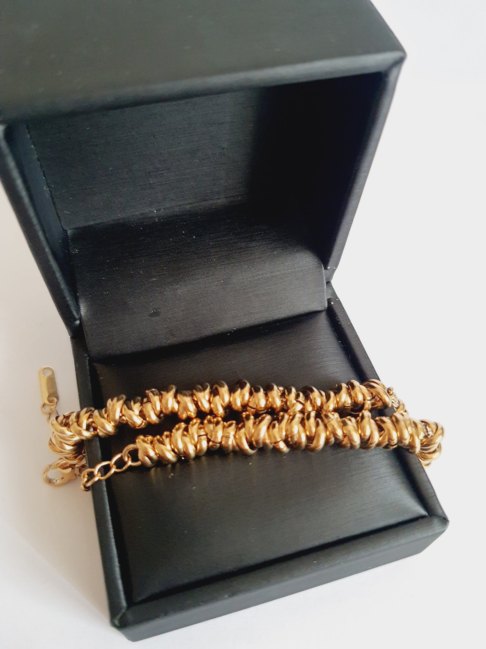 Złota bransoletka ze stali nierdzewnej, masywna forma ze splecionymi elementami, długość regulowana 18–24 cm, elegancki styl glamour. Rouge Bizu.