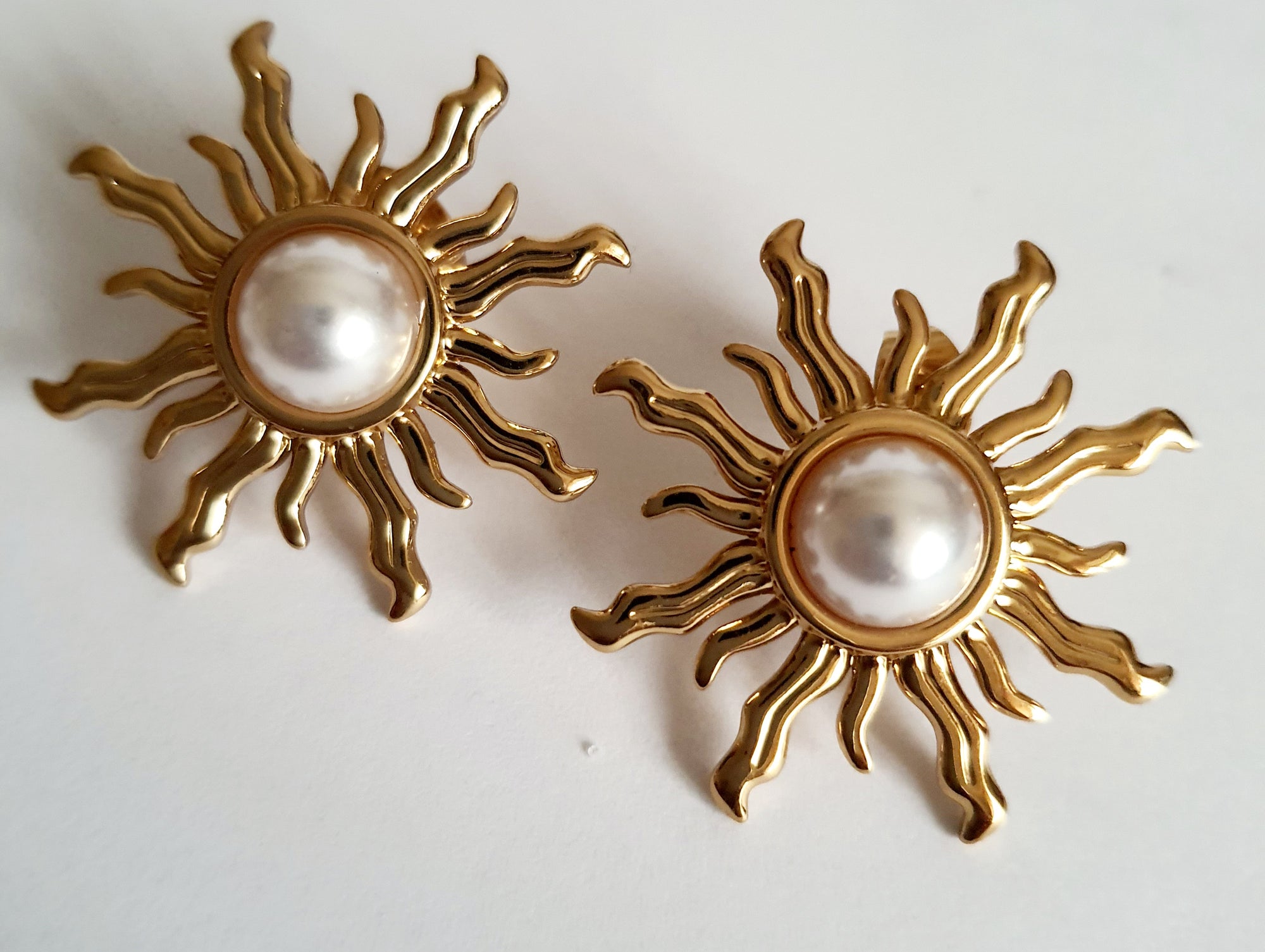 Złote kolczyki ze stali nierdzewnej w kształcie słońca z perłowym środkiem, średnica 3 cm, styl artystyczny i glamour. Rouge Bizu.