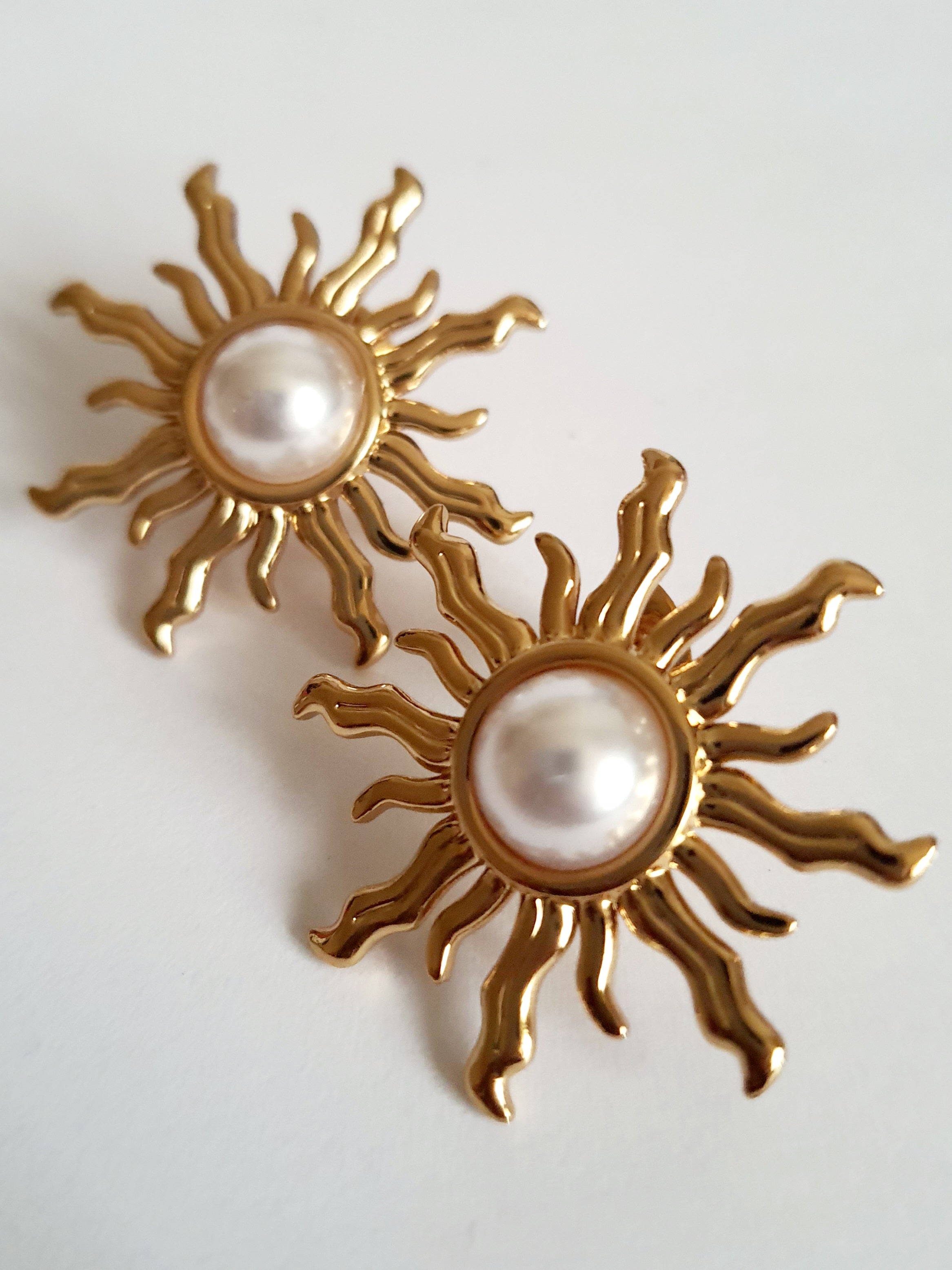 Złote kolczyki ze stali nierdzewnej w kształcie słońca z perłowym środkiem, średnica 3 cm, styl artystyczny i glamour. Rouge Bizu.