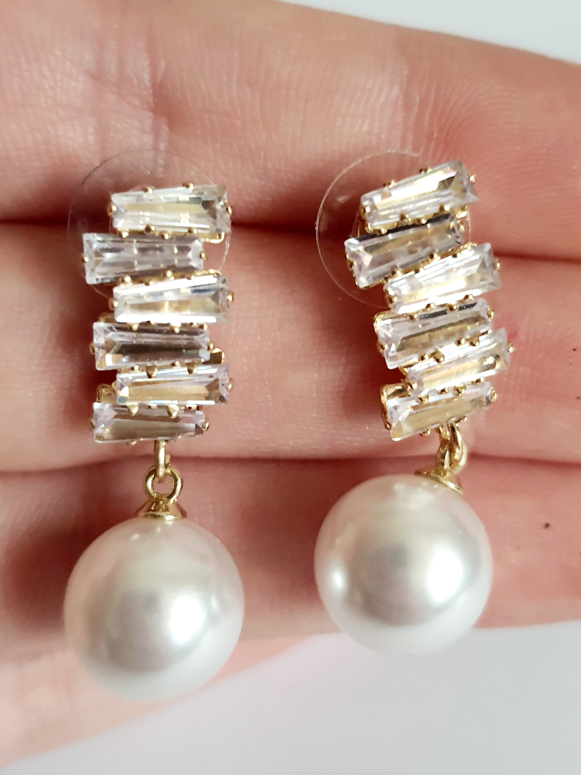 Złote kolczyki ze stali nierdzewnej z cyrkoniami i dużą perłą syntetyczną, długość 3 cm, elegancki styl glamour. Rouge Bizu.