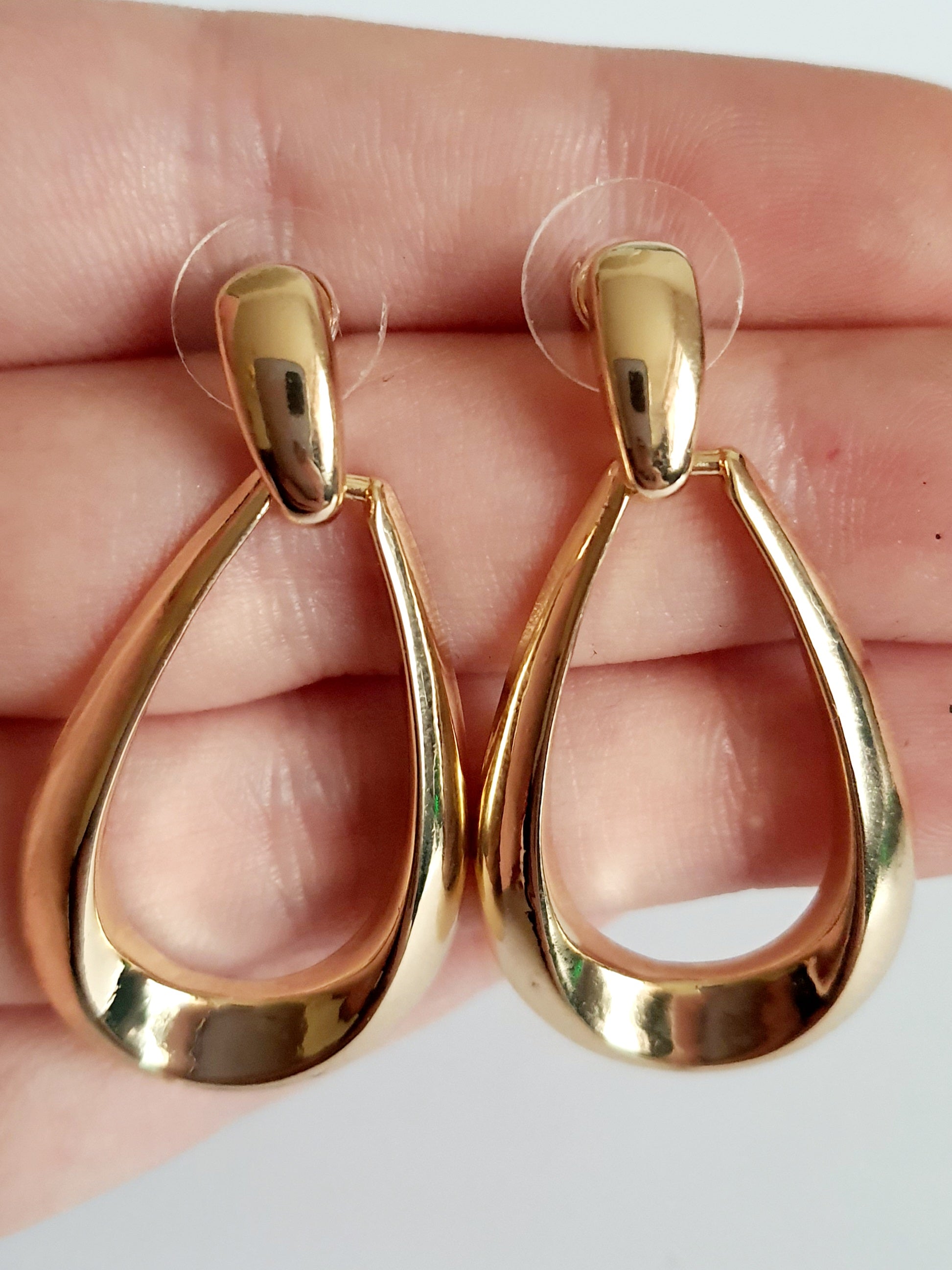 Złote kolczyki ze stali nierdzewnej w kształcie minimalistycznych kropli, eleganckie i ponadczasowe, długość 4 cm. Rouge Bizu.