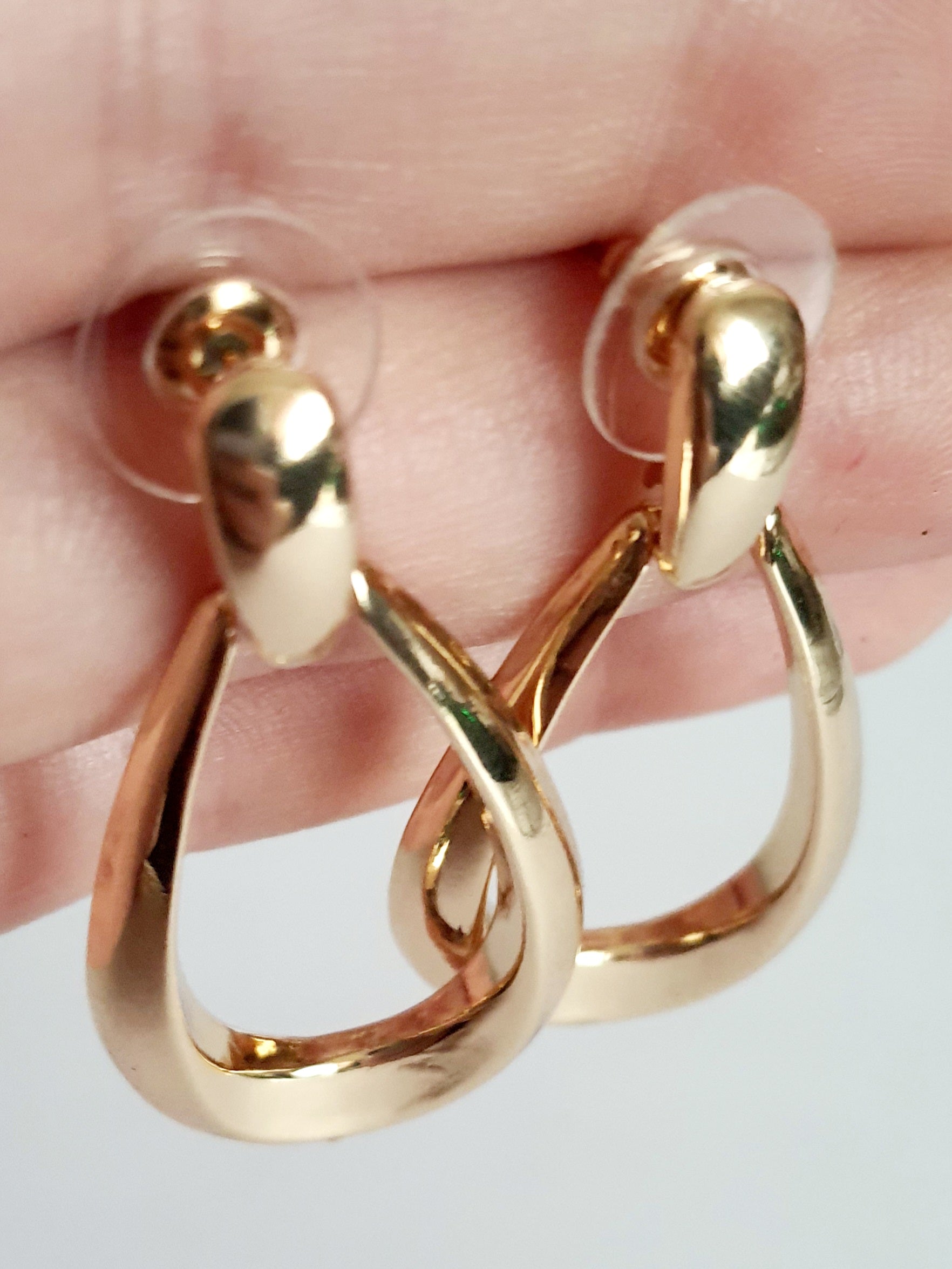 Złote kolczyki ze stali nierdzewnej w kształcie minimalistycznych kropli, eleganckie i ponadczasowe, długość 4 cm. Rouge Bizu.