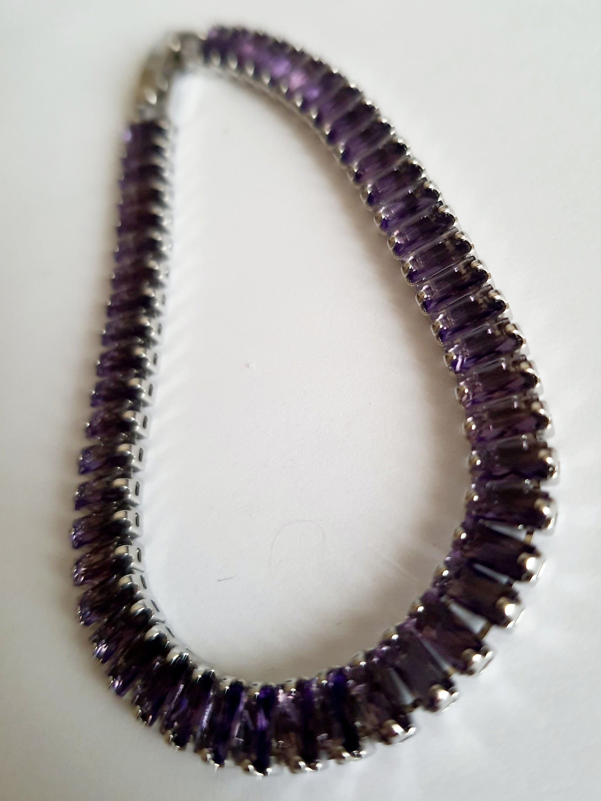 Srebrna bransoletka ze stali nierdzewnej zdobiona fioletowymi kamieniami syntetycznymi, długość 18 cm, elegancki i wieczorowy styl glamour. Rouge Bizu.