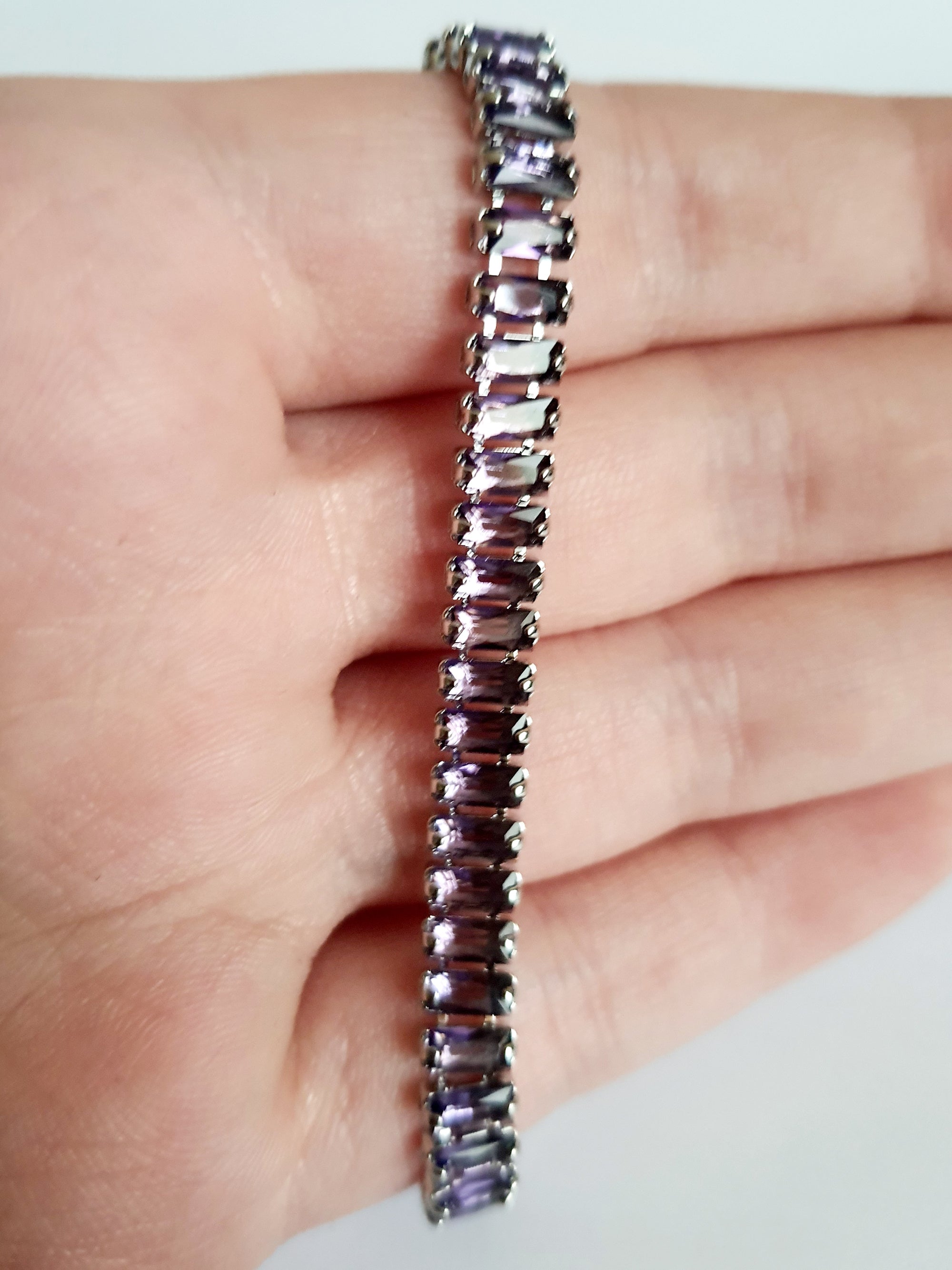 Srebrna bransoletka ze stali nierdzewnej zdobiona fioletowymi kamieniami syntetycznymi, długość 18 cm, elegancki i wieczorowy styl glamour. Rouge Bizu.
