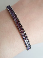 Srebrna bransoletka ze stali nierdzewnej zdobiona fioletowymi kamieniami syntetycznymi, długość 18 cm, elegancki i wieczorowy styl glamour. Rouge Bizu.