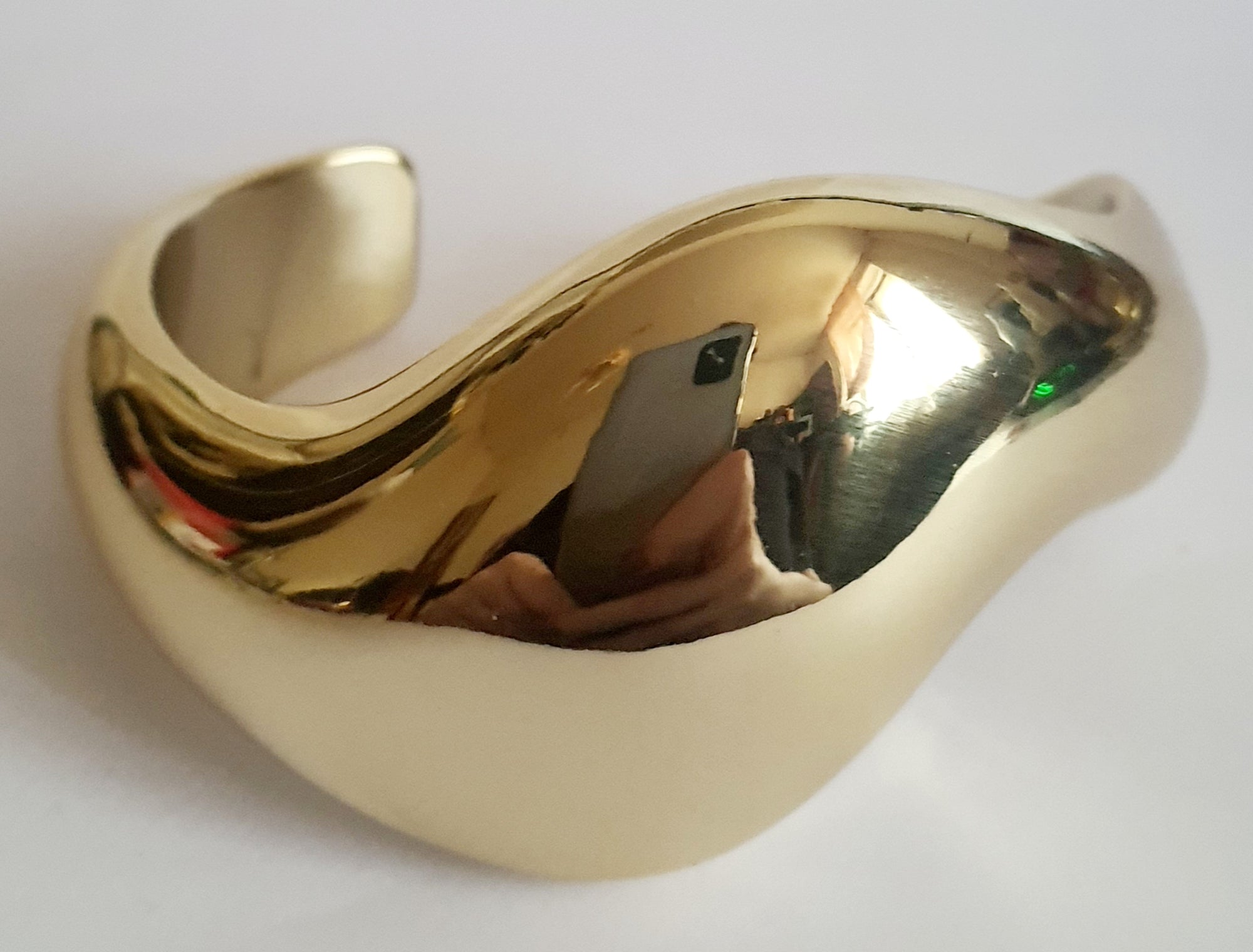 Złota sztywna bransoletka ze stali nierdzewnej, rzeźbiarska i falująca forma, średnica 6 cm, artystyczny i nowoczesny design, Rouge Bizu.