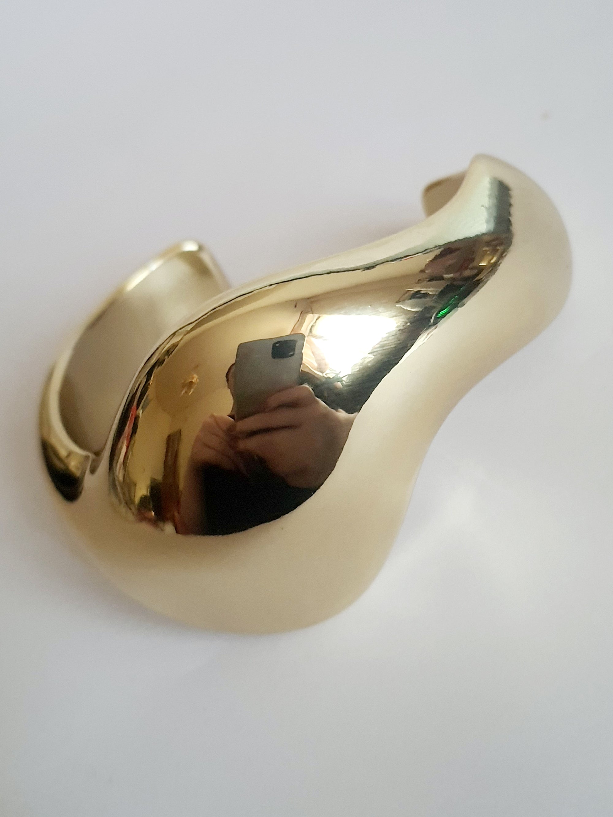 Złota sztywna bransoletka ze stali nierdzewnej, rzeźbiarska i falująca forma, średnica 6 cm, artystyczny i nowoczesny design, Rouge Bizu.