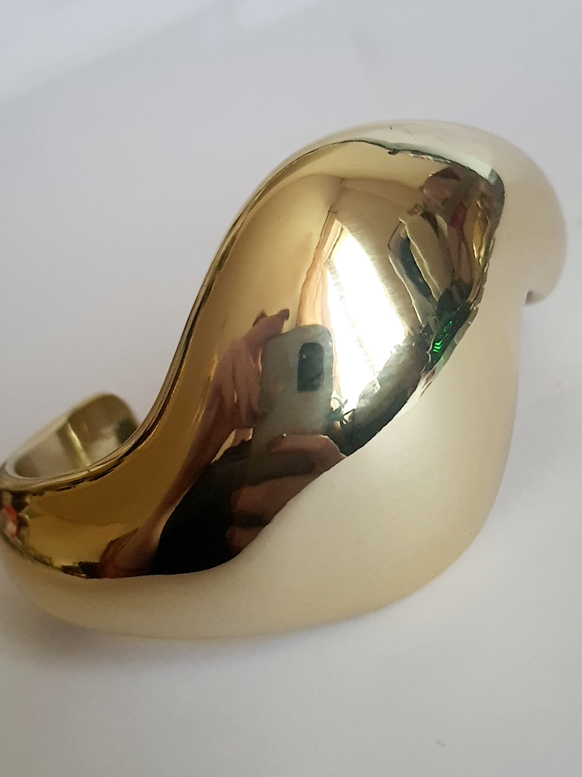 Złota sztywna bransoletka ze stali nierdzewnej, rzeźbiarska i falująca forma, średnica 6 cm, artystyczny i nowoczesny design, Rouge Bizu.
