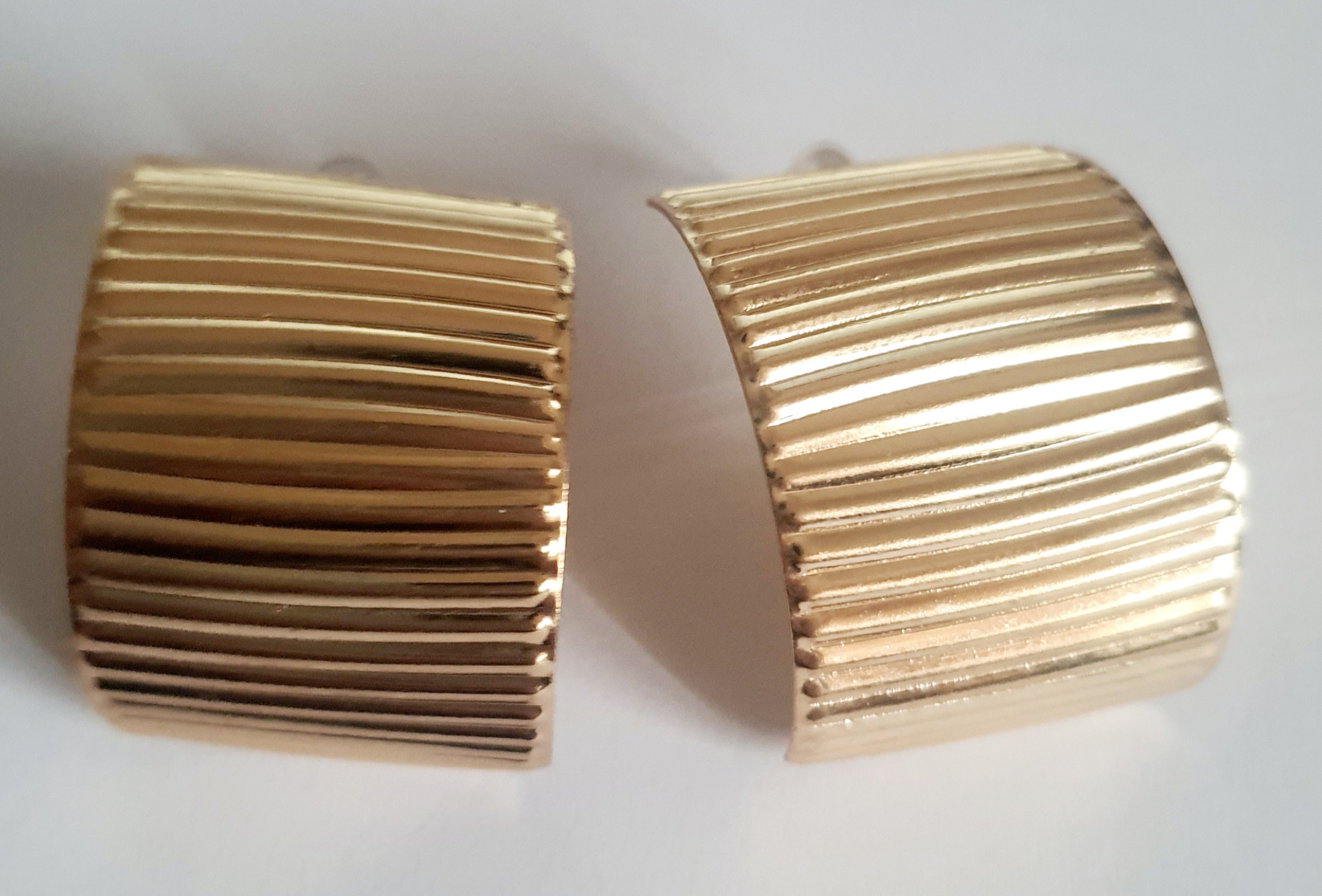 Złote kolczyki szerokie z pionowym tłoczeniem, minimalistyczne i eleganckie. Stal nierdzewna, długość 3 cm. Rouge Bizu.