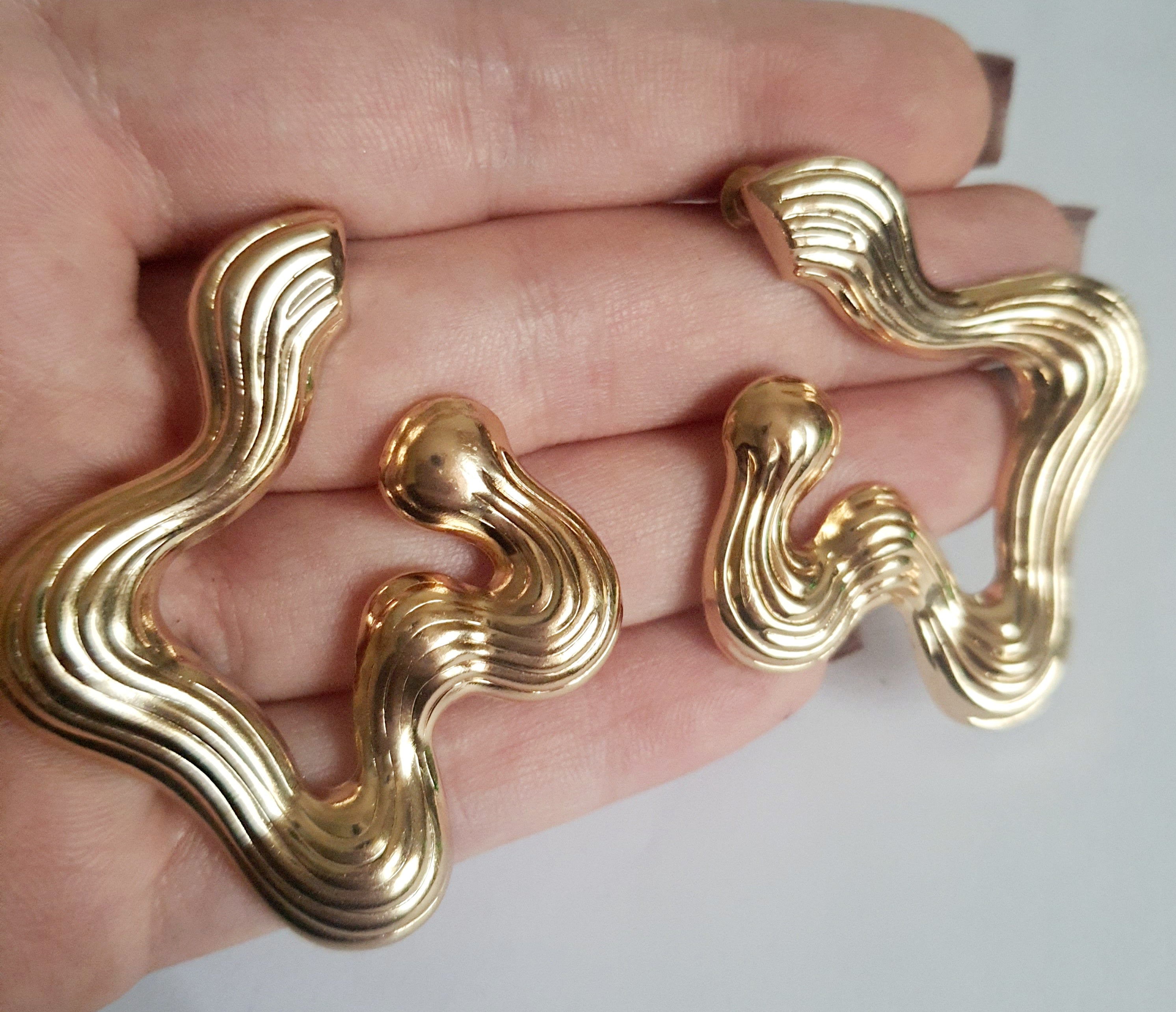 Złote kolczyki falujące o artystycznej, nieregularnej formie, eleganckie i nowoczesne. Stal nierdzewna, długość 5 cm. Rouge Bizu.