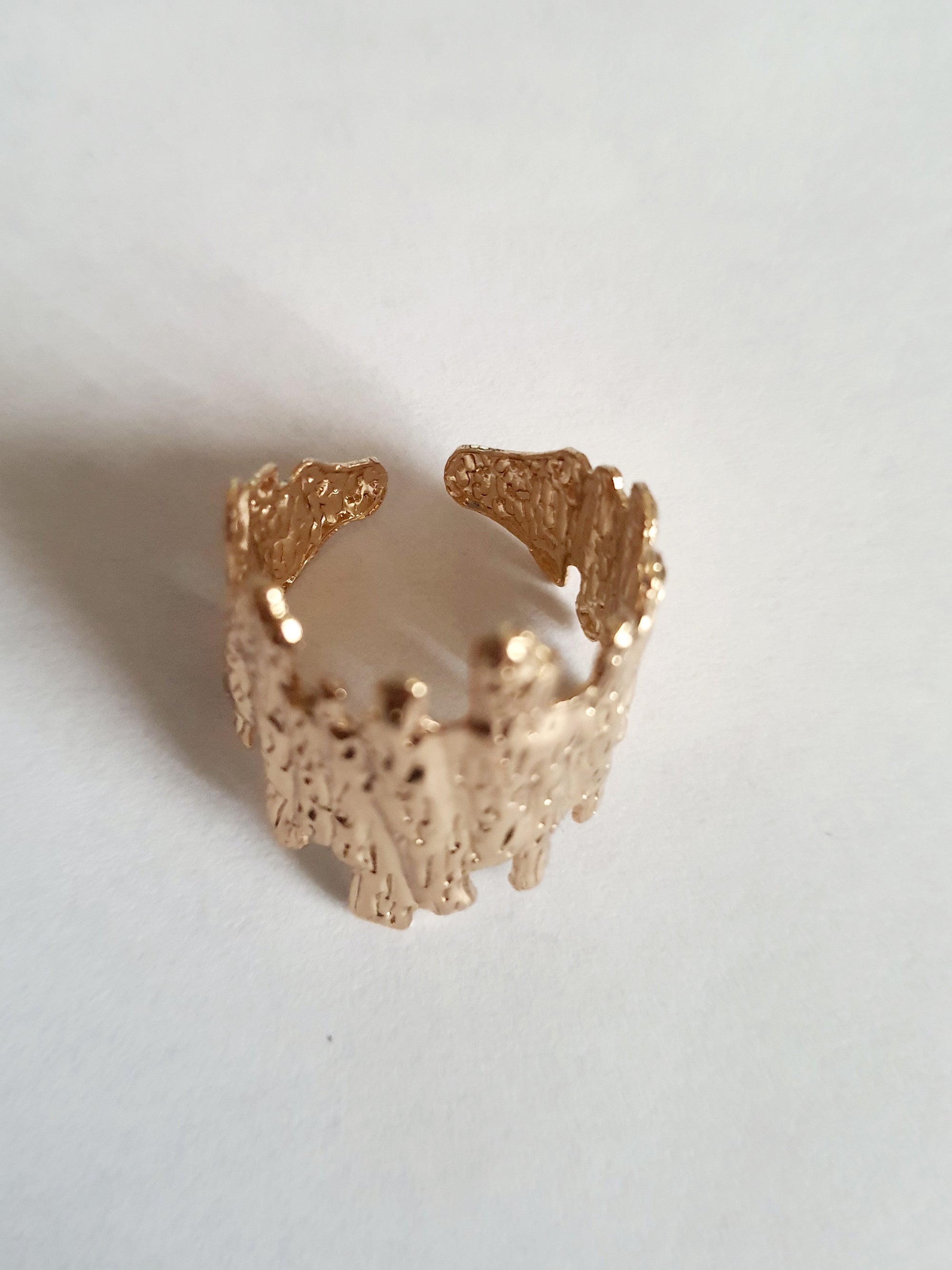 Złoty pierścionek ze stali nierdzewnej o organicznej fakturze, przypominającej skałę lub strukturę kory. Styl artystyczny i nowoczesny. Rozmiar 19 mm. Rouge Bizu.