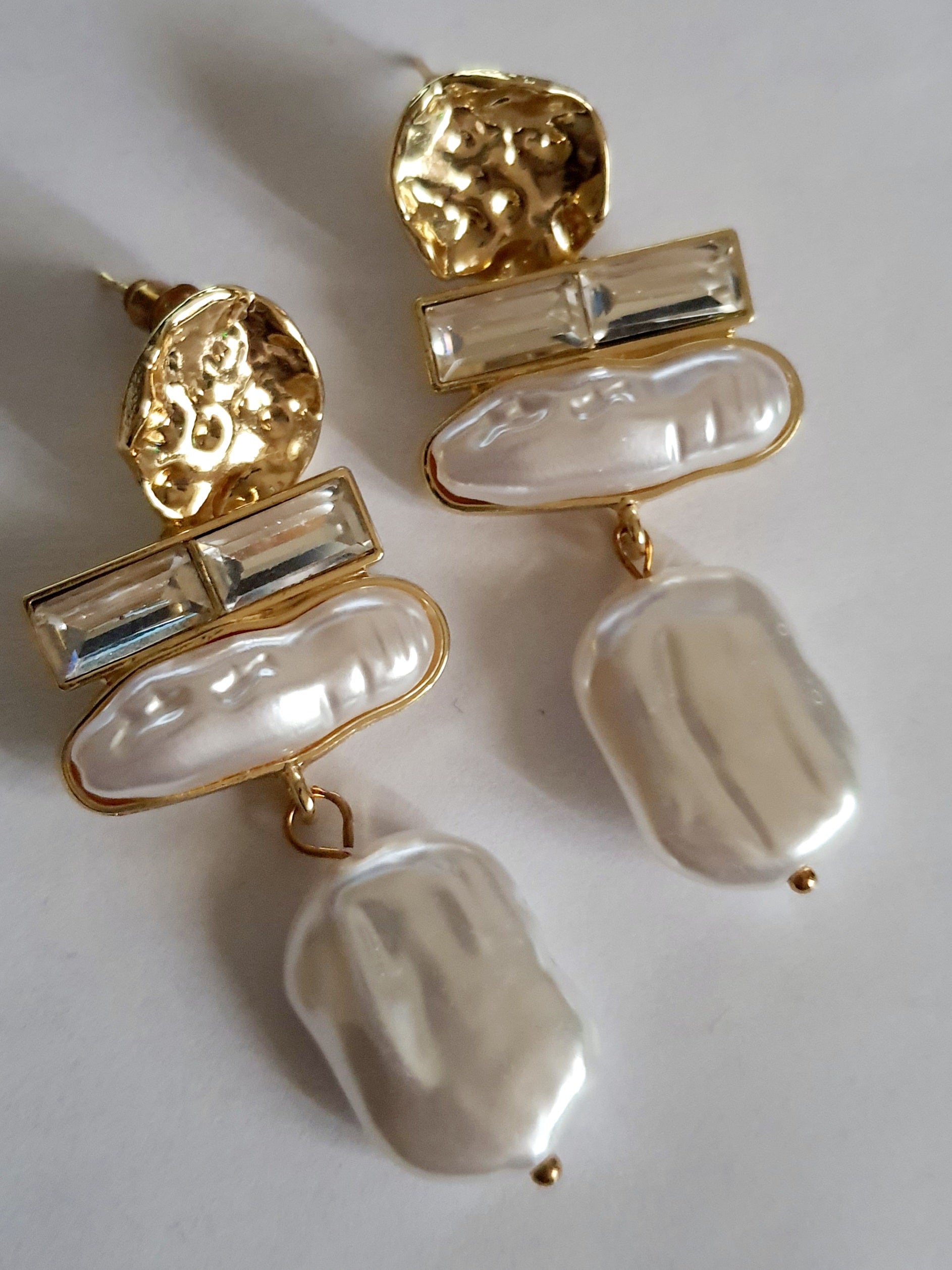 „Złote kolczyki ze stali nierdzewnej o długości 6 cm, zdobione nieregularnymi perłami barokowymi oraz prostokątnymi kryształami, eleganckie i stylowe – Rouge Bizu.”