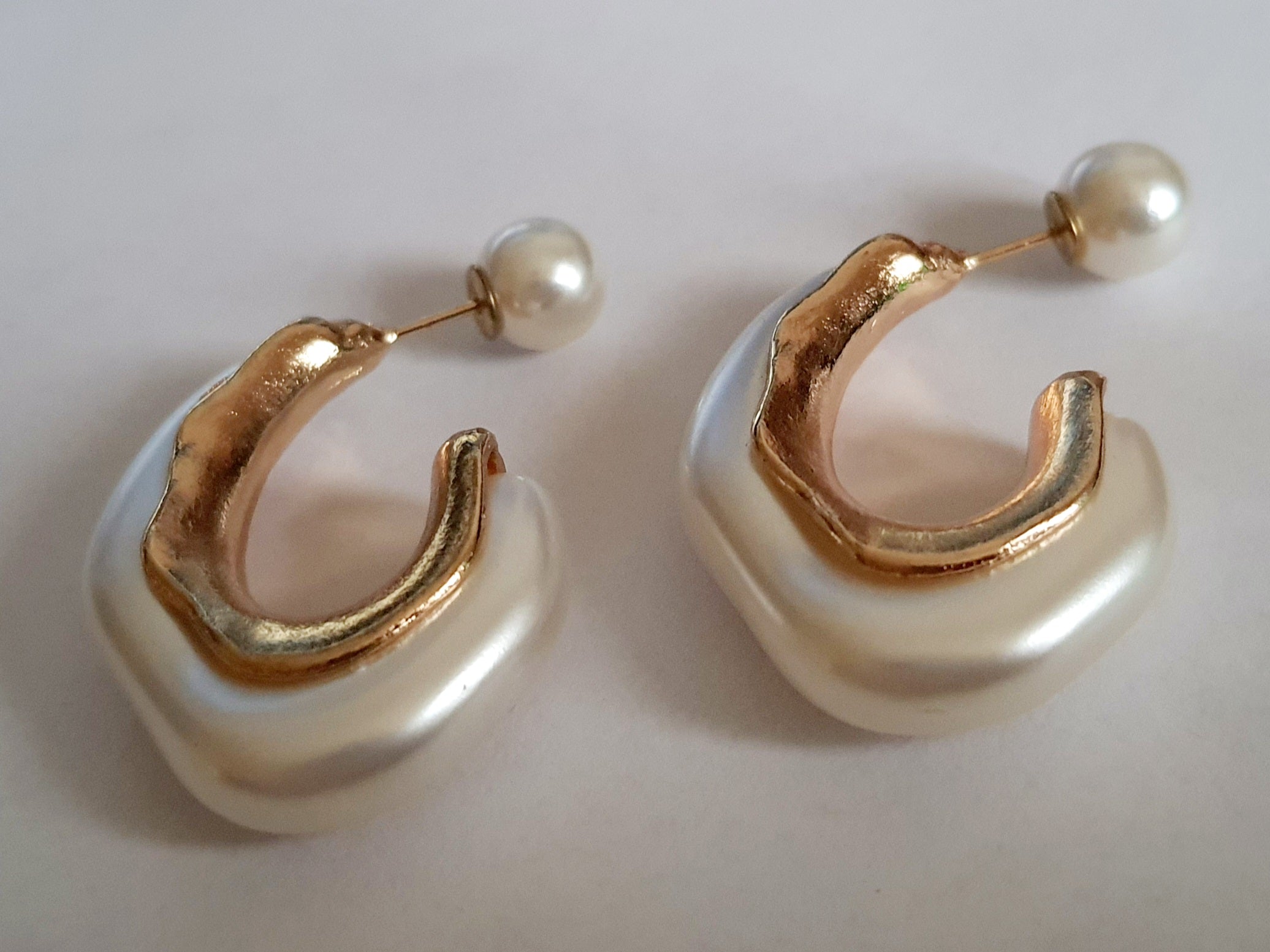 „Złote kolczyki ze stali nierdzewnej o długości 4 cm, z perłowym wykończeniem i nowoczesną organiczną formą, eleganckie i artystyczne – Rouge Bizu.”