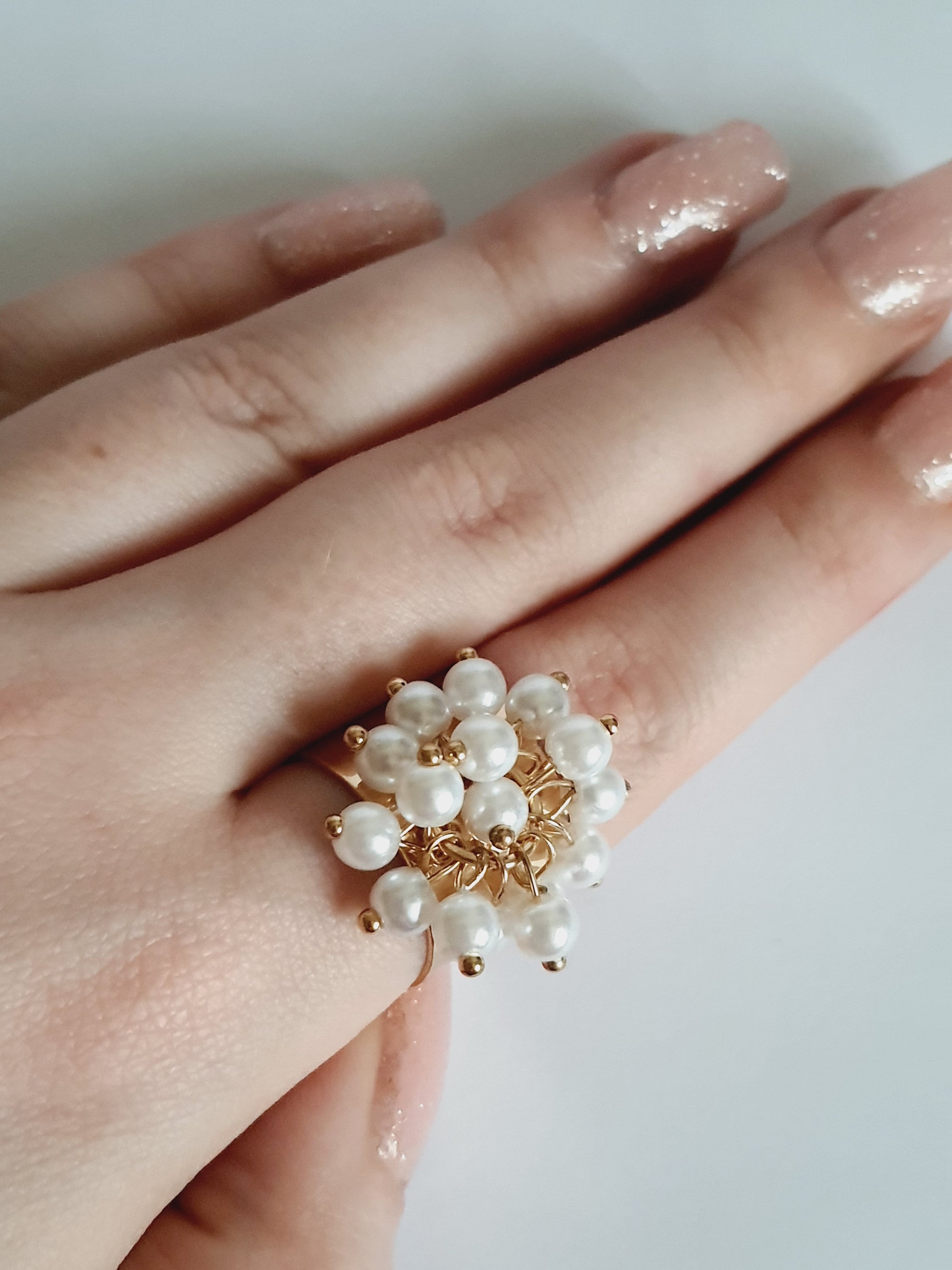 Pierścionek glamour ze stali nierdzewnej, złocony, szeroki regulowany, ozdobiony bukietem białych syntetycznych perełek, rozmiar 19 mm, RougeBizu.