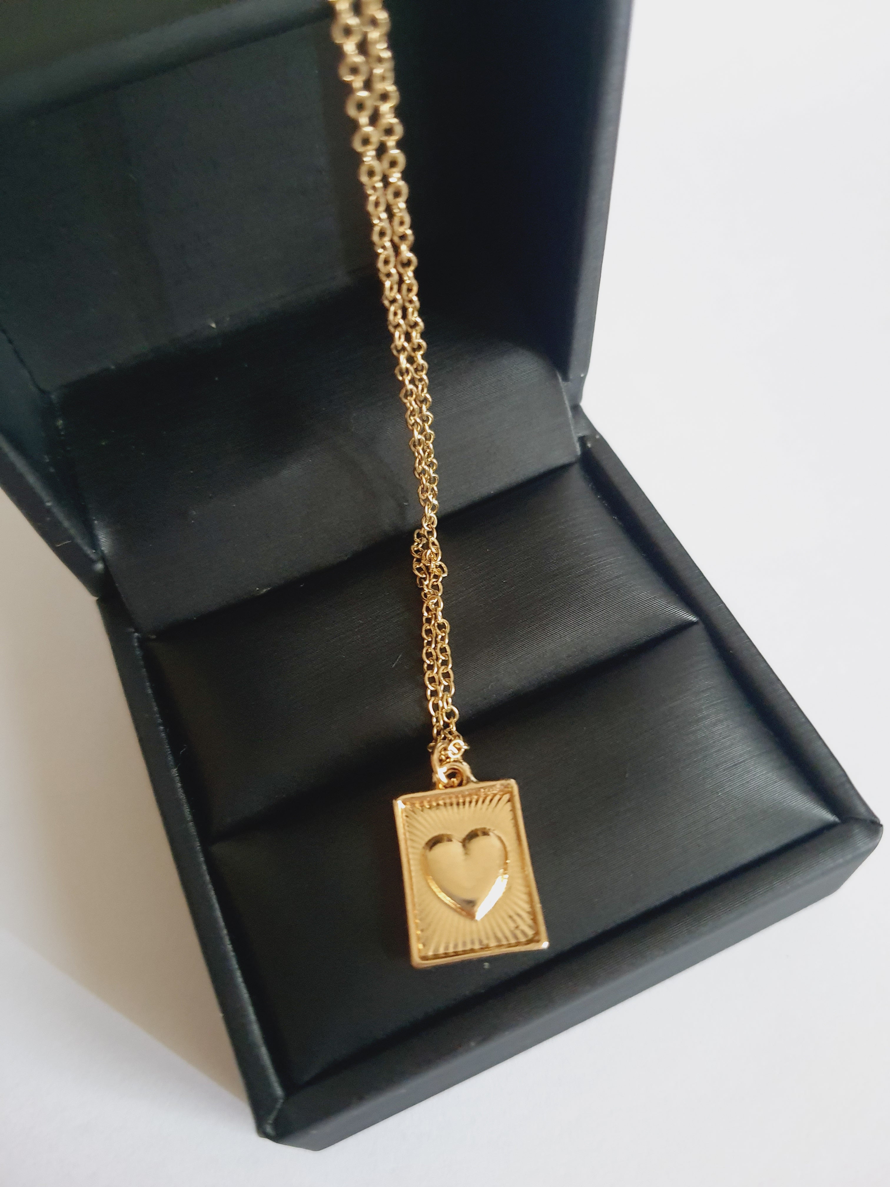 Złocony łańcuszek ze stali chirurgicznej, regulowana długość 38–46,5 cm, prostokątna zawieszka z sercem i promienistym wzorem, RougeBizu.