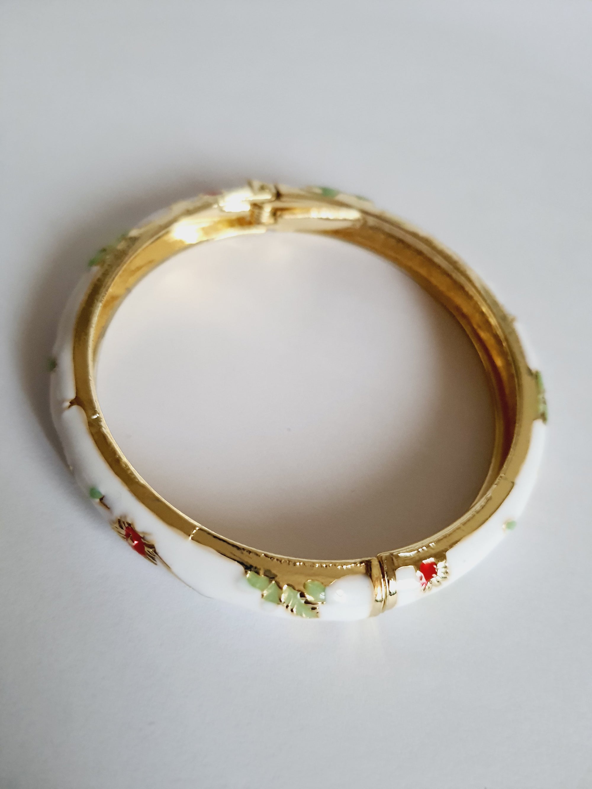 Bransoletka ze stali nierdzewnej, emaliowana na biało, zdobiona złotymi detalami i motywem kwiatowym w kolorach zieleni, czerwieni i różu, średnica 6 cm, Rouge Bizu.