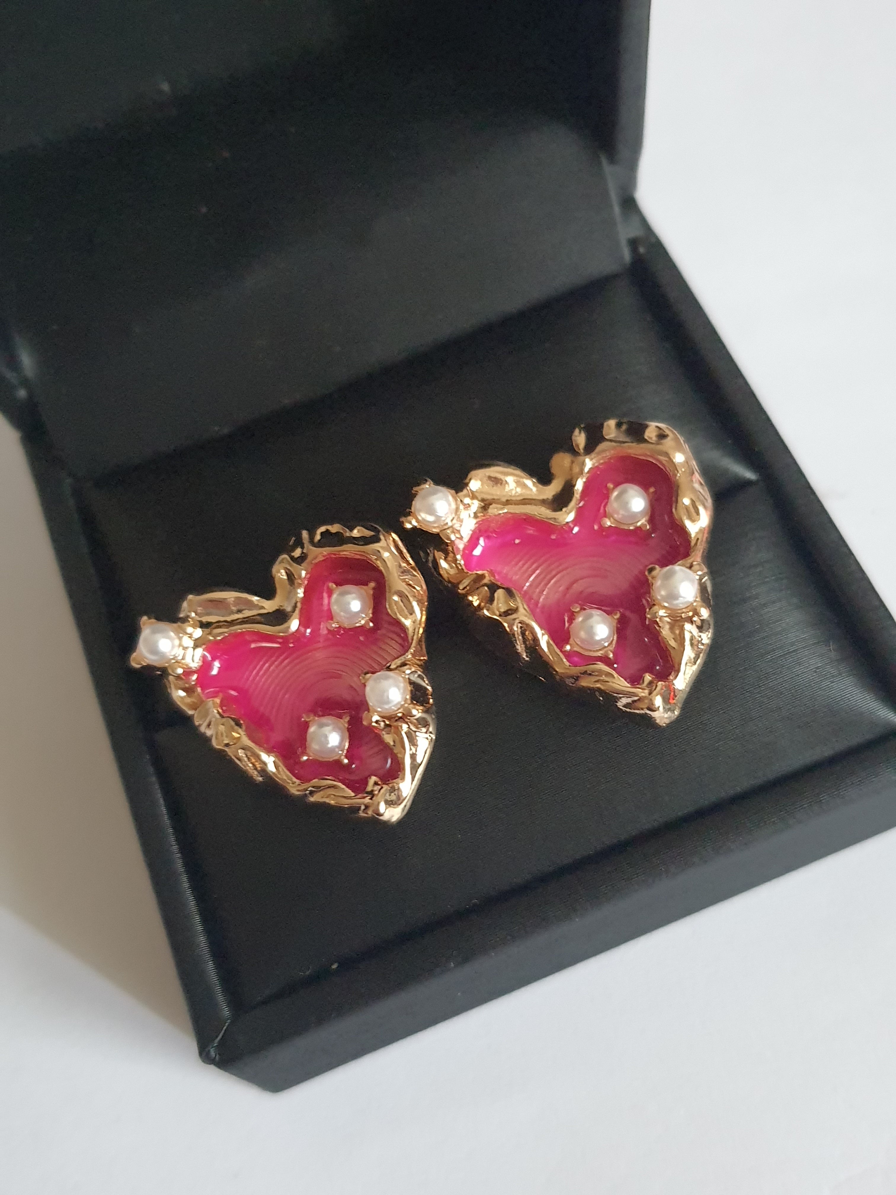 Kolczyki serca ze stali nierdzewnej w kolorze złotym, wypełnione fuksją i ozdobione drobnymi perłami, długość 2 cm, Rouge Bizu.