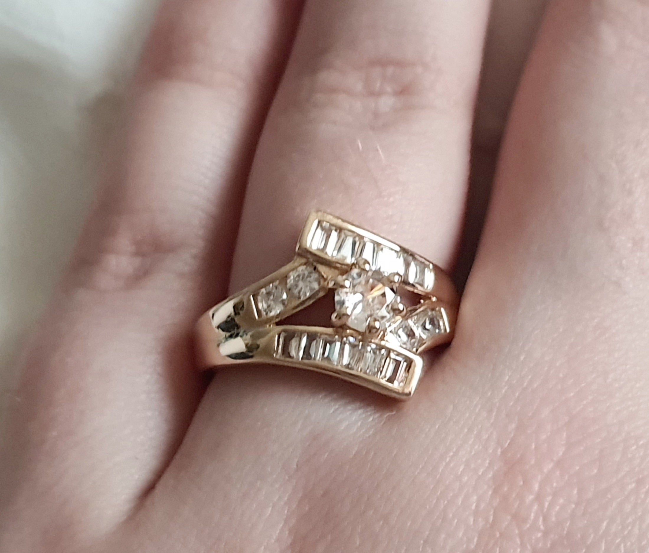 Pierścionek damski ze stali nierdzewnej, złoty, rozmiar 19 mm, zdobiony rzędami prostokątnych cyrkonii i centralnym okrągłym kamieniem, luksusowy styl glamour, Rouge Bizu.