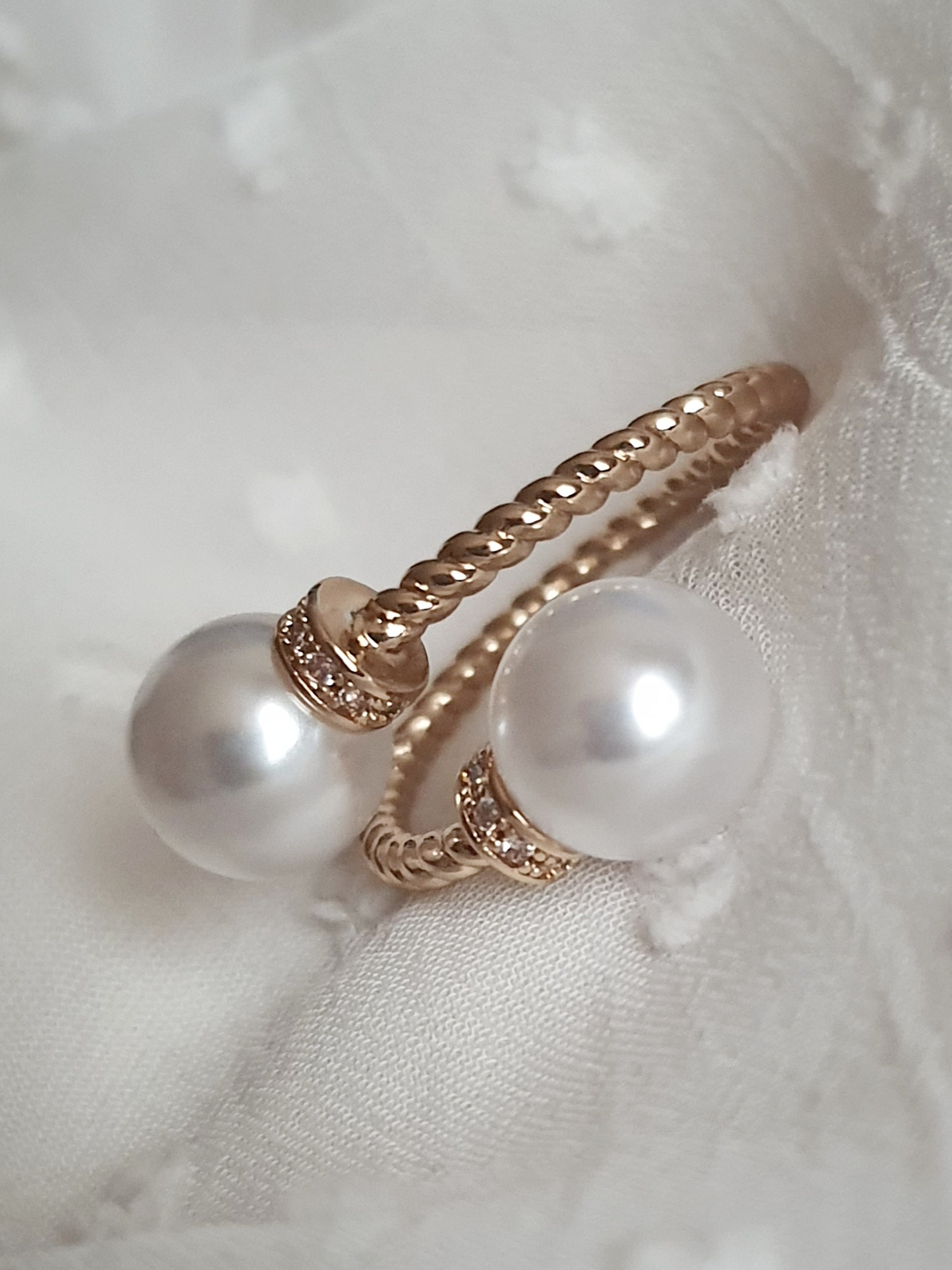 Pierścionek damski ze stali nierdzewnej, złoty, rozmiar 19 mm, zdobiony dwiema syntetycznymi perłami i drobnymi cyrkoniami, pleciona obrączka, elegancki styl glamour, Rouge Bizu.