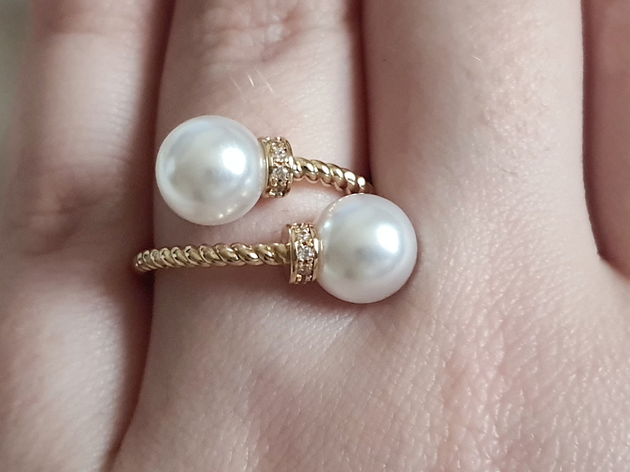 Pierścionek damski ze stali nierdzewnej, złoty, rozmiar 19 mm, zdobiony dwiema syntetycznymi perłami i drobnymi cyrkoniami, pleciona obrączka, elegancki styl glamour, Rouge Bizu.