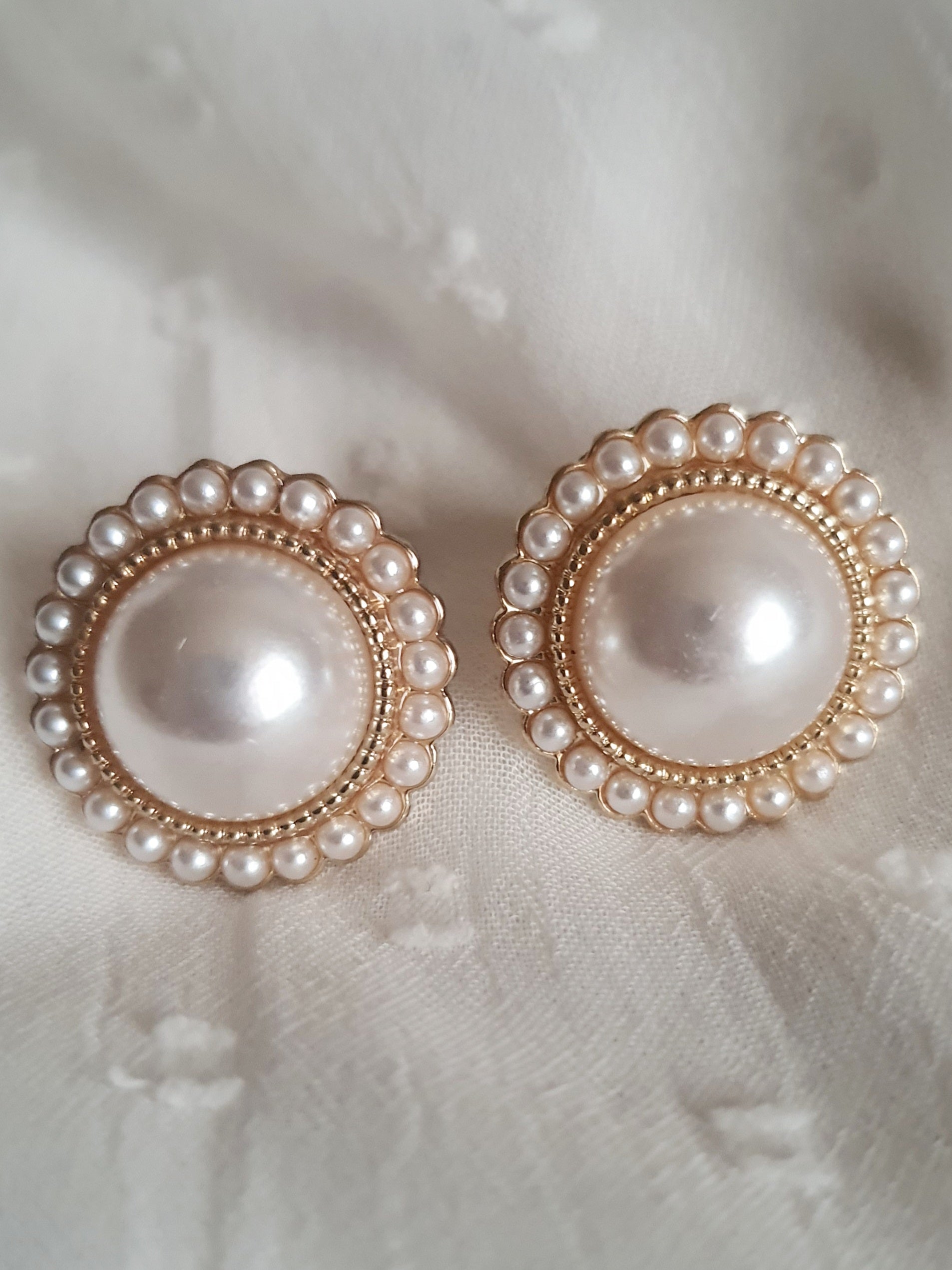 Kolczyki damskie ze stali nierdzewnej, średnica 2 cm, złote wykończenie, centralna duża perła otoczona drobnymi perełkami, klasyczny glamour retro, Rouge Bizu.