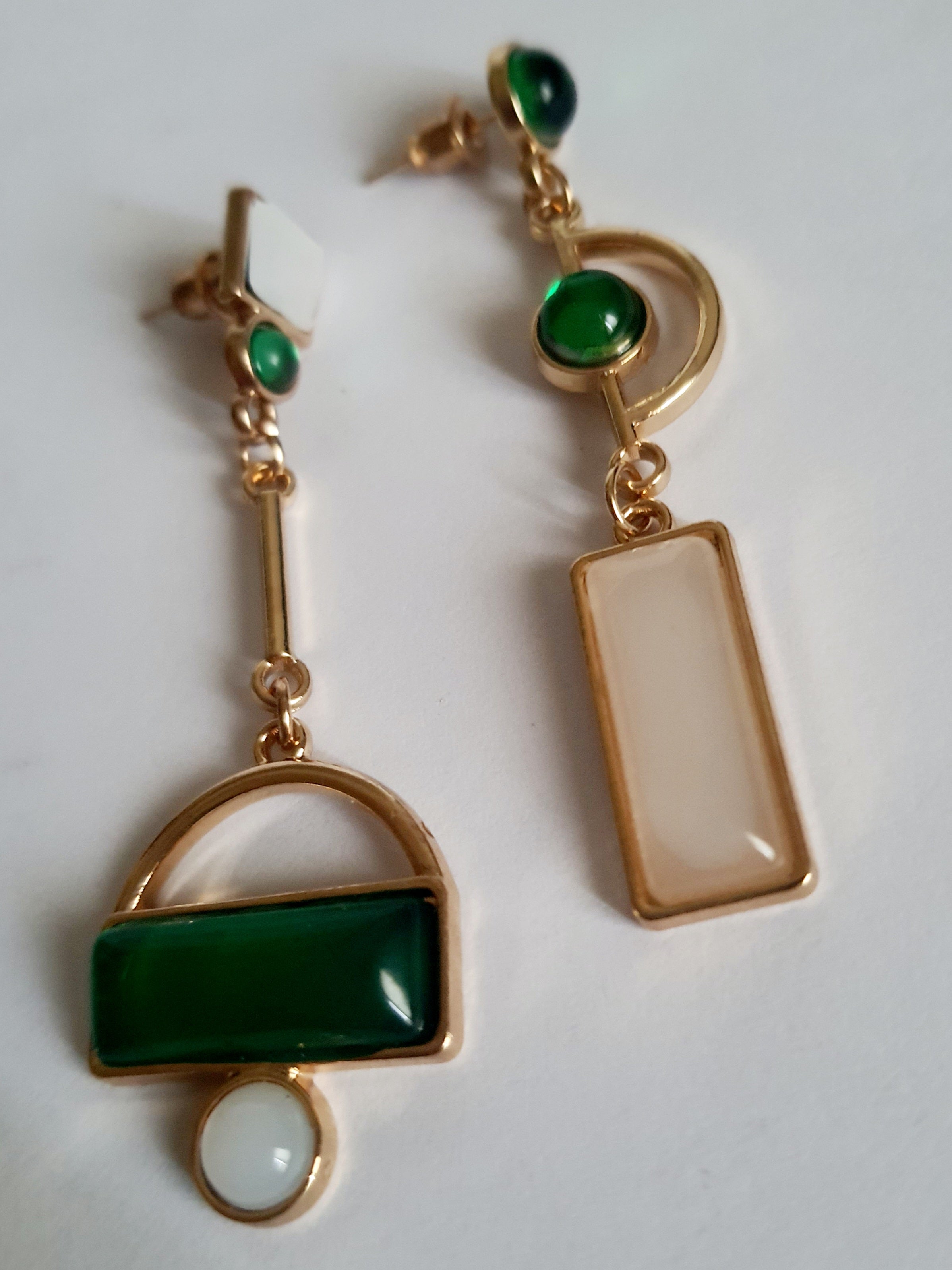 Kolczyki geometryczne ze stali nierdzewnej w kolorze złota, z zielonymi i białymi elementami w różnych kształtach. Asymetryczna forma, długość 6 cm. Styl nowoczesny i elegancki. Rouge Bizu.