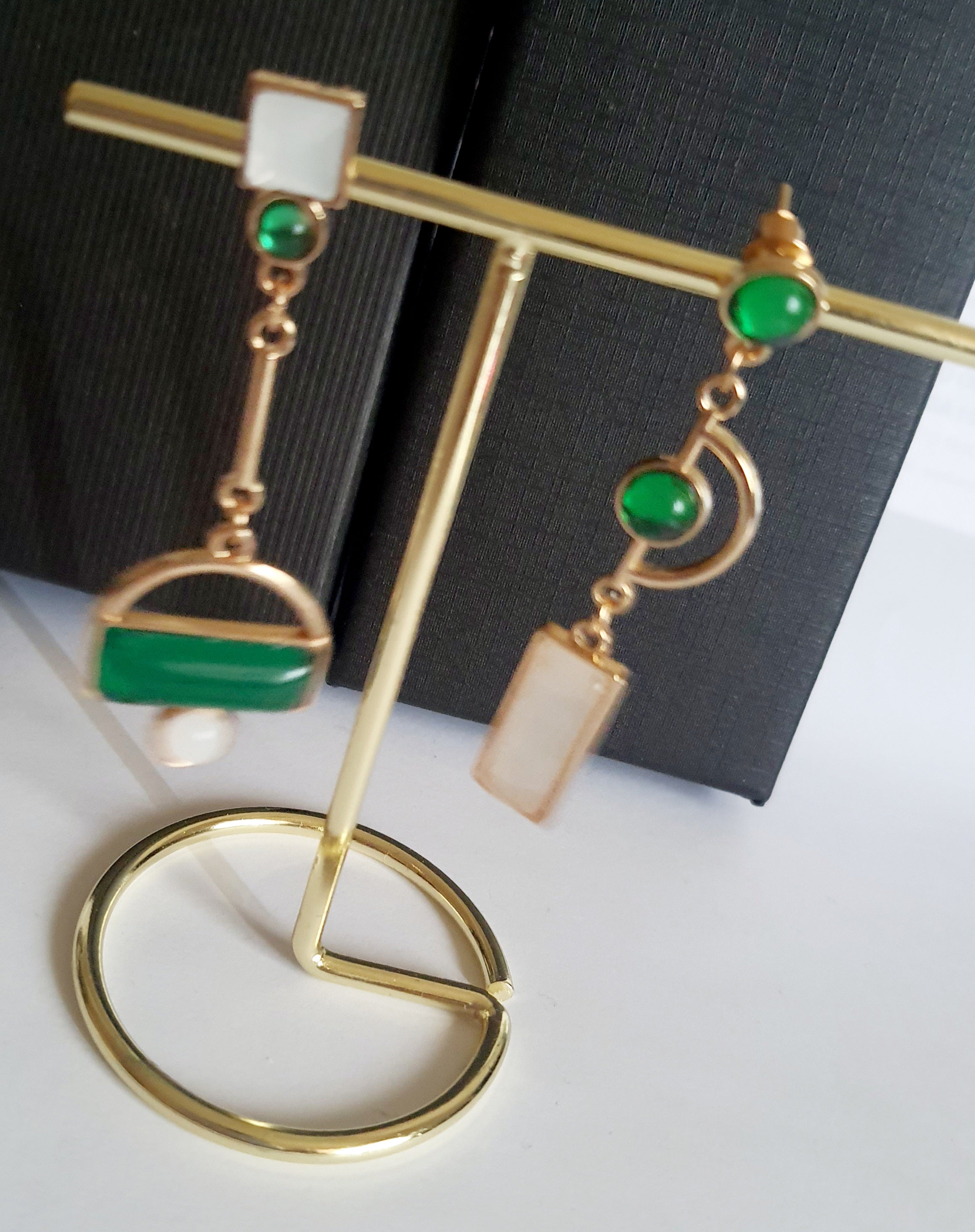 Kolczyki geometryczne ze stali nierdzewnej w kolorze złota, z zielonymi i białymi elementami w różnych kształtach. Asymetryczna forma, długość 6 cm. Styl nowoczesny i elegancki. Rouge Bizu.