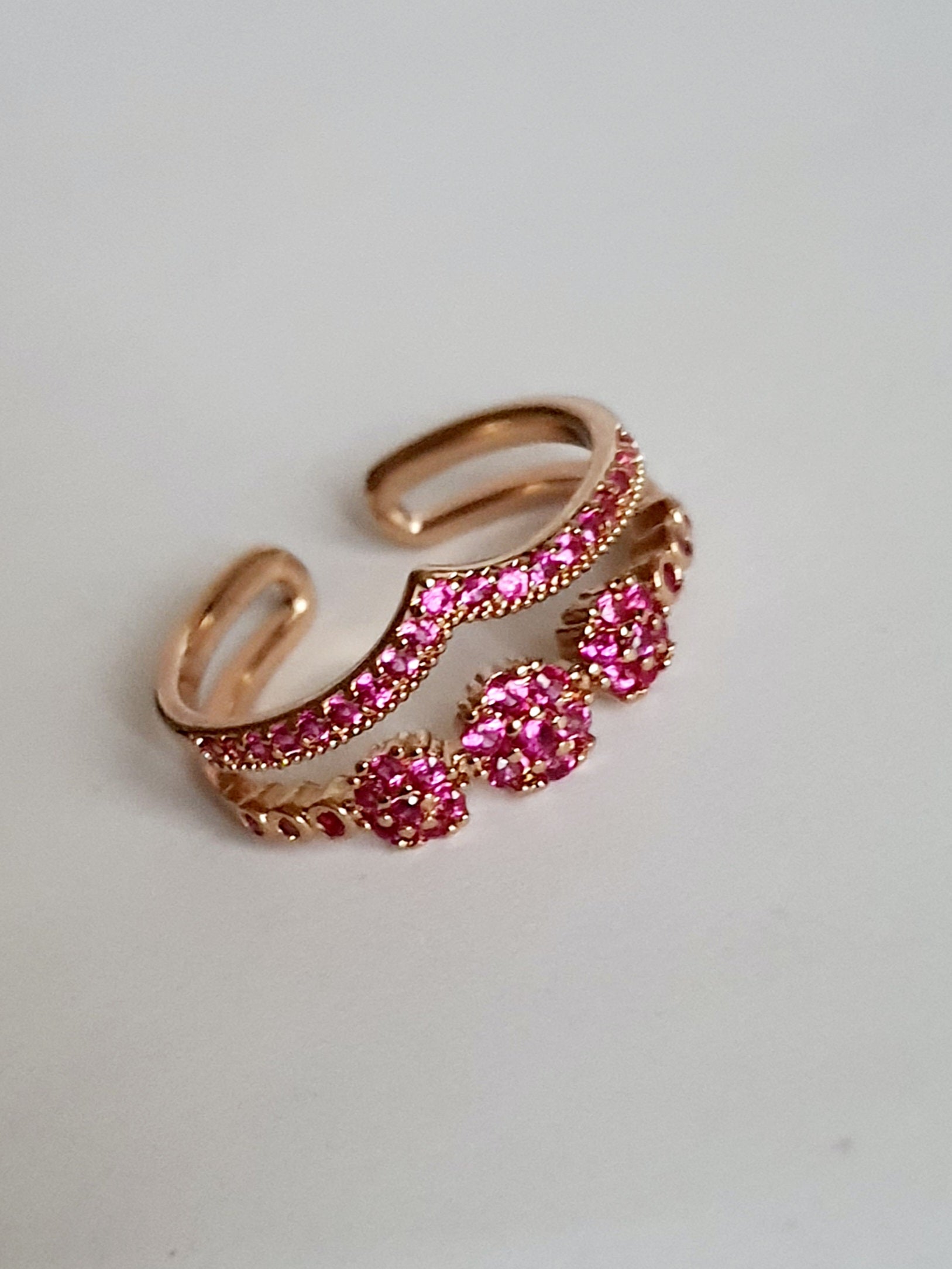 Pierścionek ze stali nierdzewnej w kolorze złota, zdobiony różowymi cyrkoniami w formie kwiatowych motywów. Rozmiar 17 mm. Styl romantyczny i glamour. Rouge Bizu.