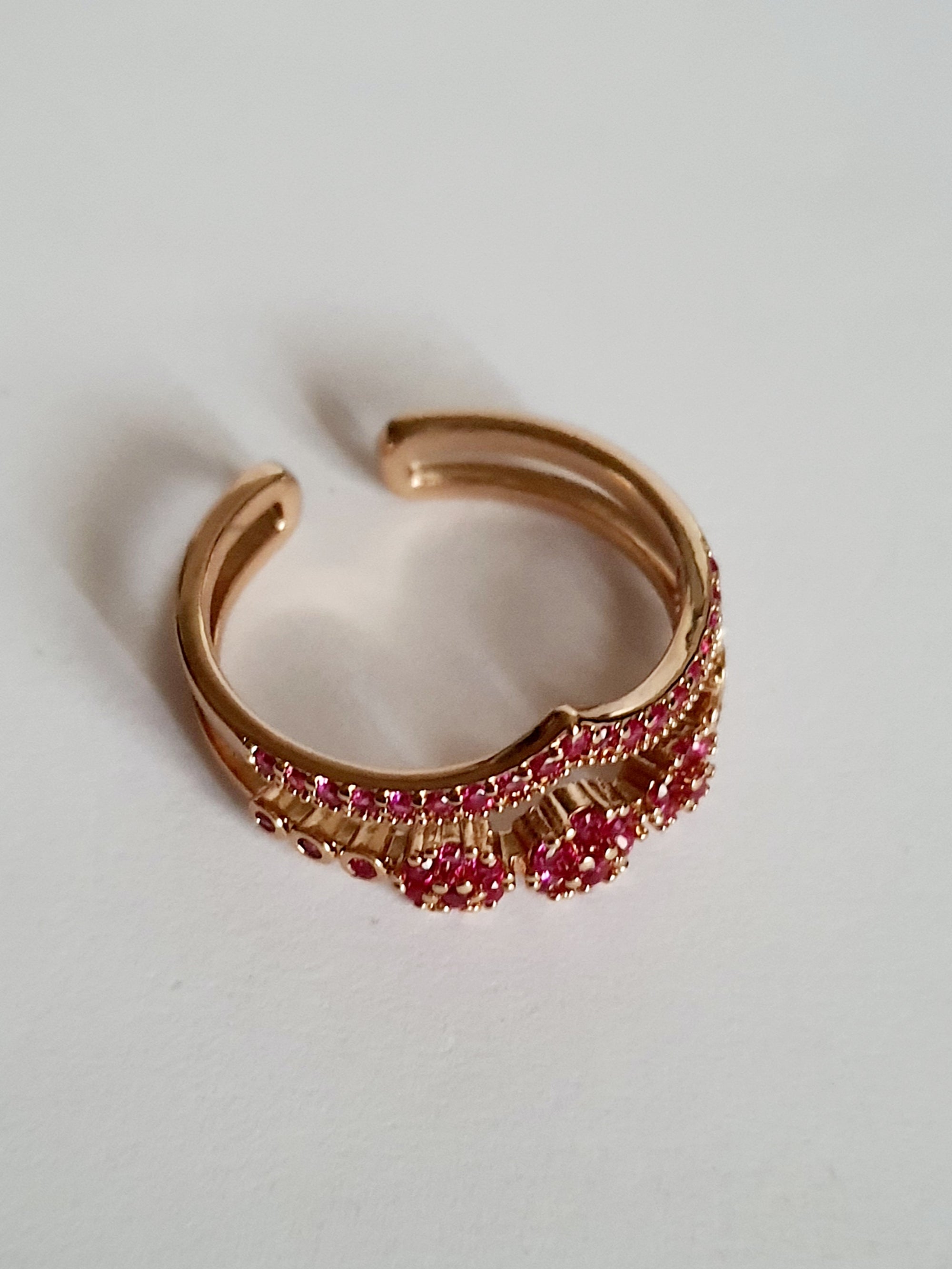 Pierścionek ze stali nierdzewnej w kolorze złota, zdobiony różowymi cyrkoniami w formie kwiatowych motywów. Rozmiar 17 mm. Styl romantyczny i glamour. Rouge Bizu.