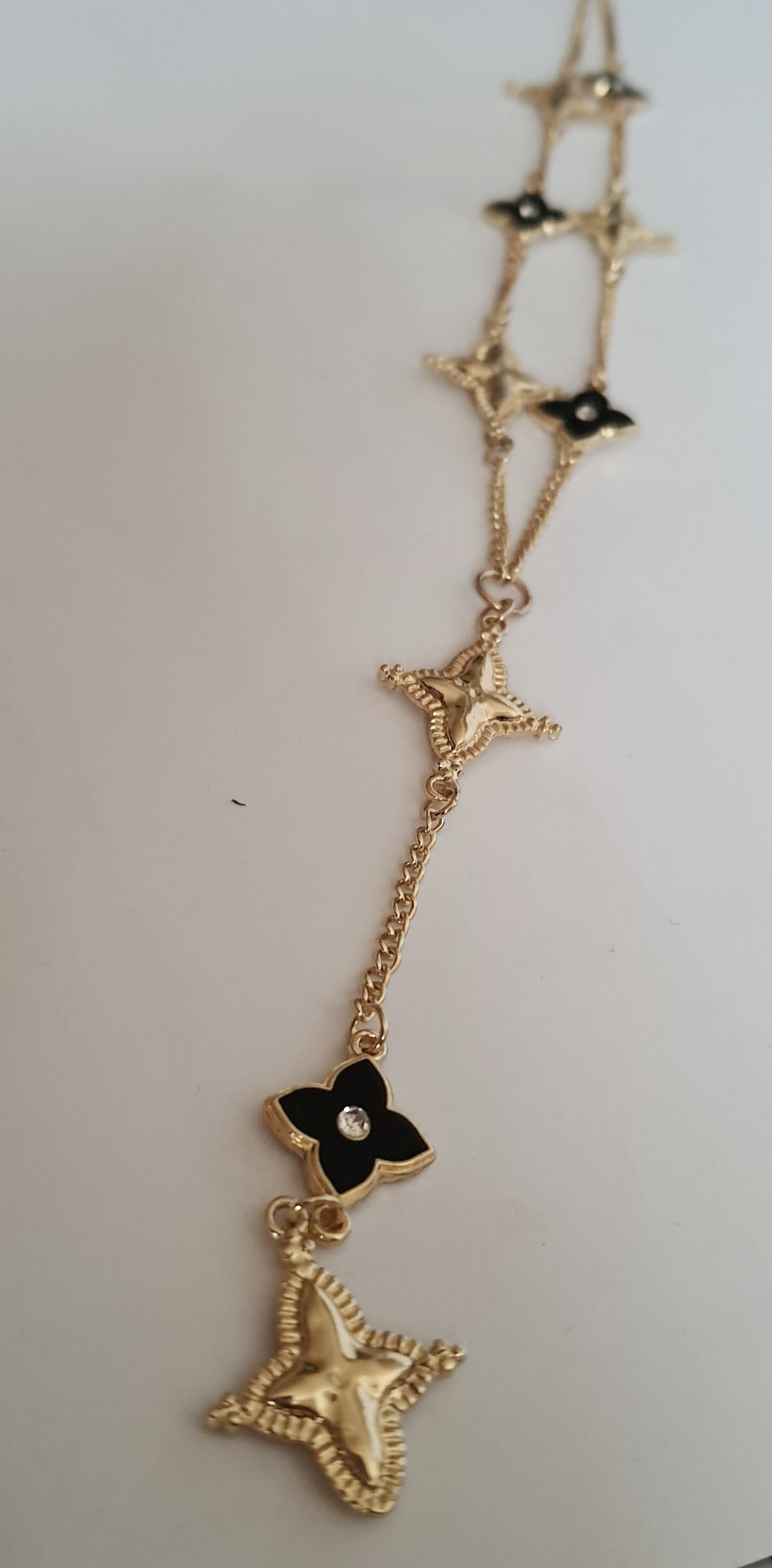 Naszyjnik złoty 58–65 cm ze stali nierdzewnej, zdobiony naprzemiennymi złotymi i czarnymi kwiatami z kryształkami, elegancki glamour, Rouge Bizu.